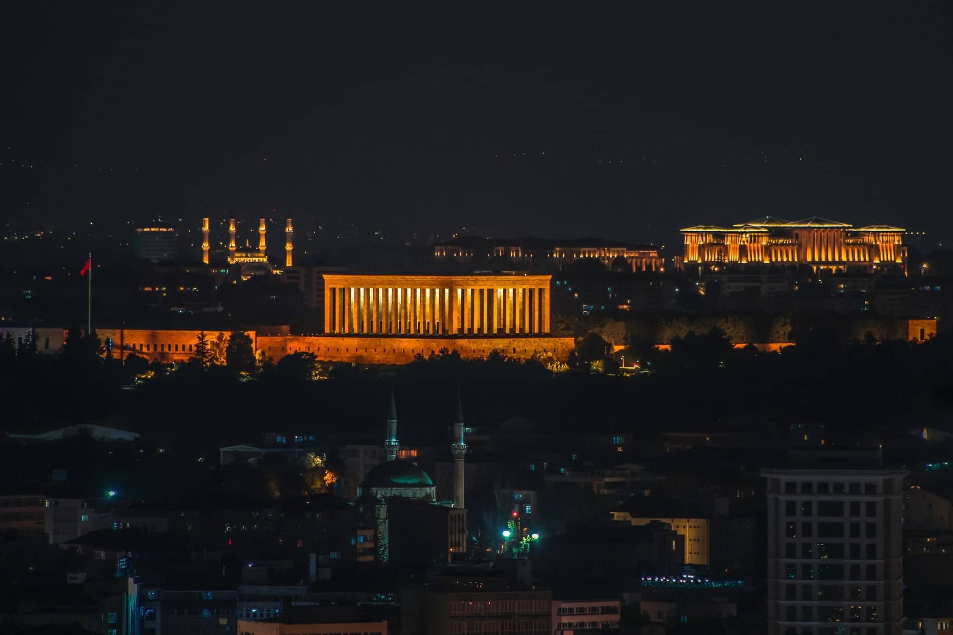 Illuminated Anıtkabir at night in Ankara cityscape, showcasing iconic architecture.