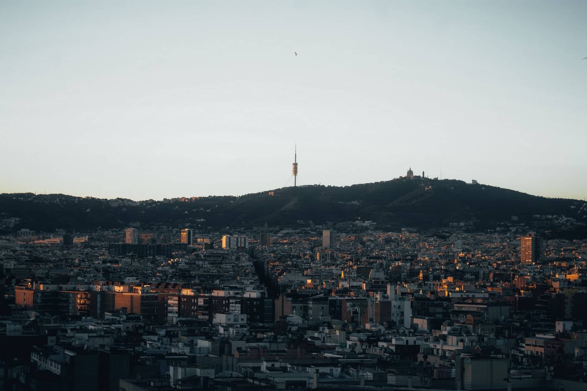 Stunning view of Barcelona with Collserola Tower silhouetted against the evening sky.