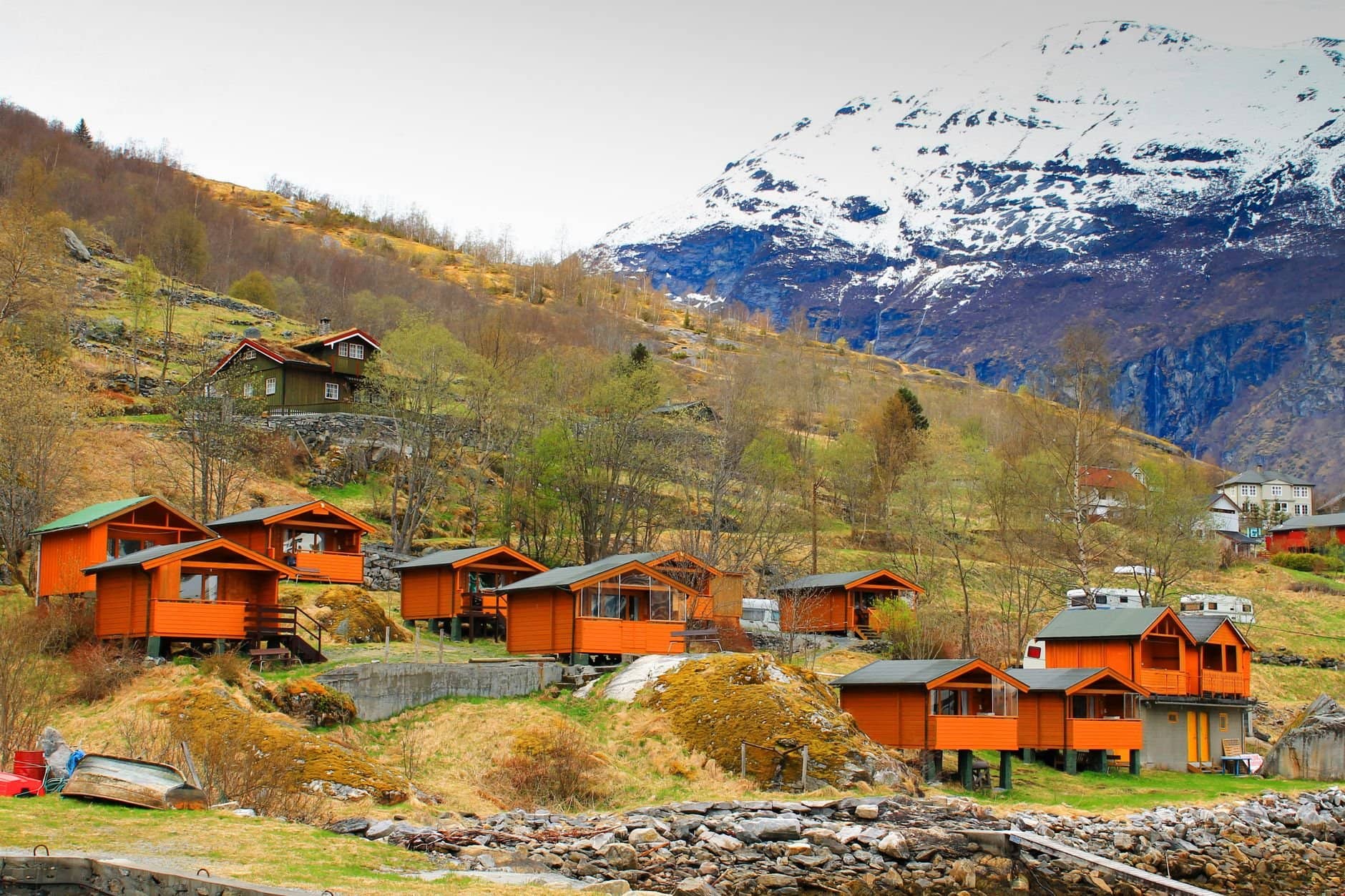 Charming Norwegian village nestled in the mountains with vibrant orange cabins.