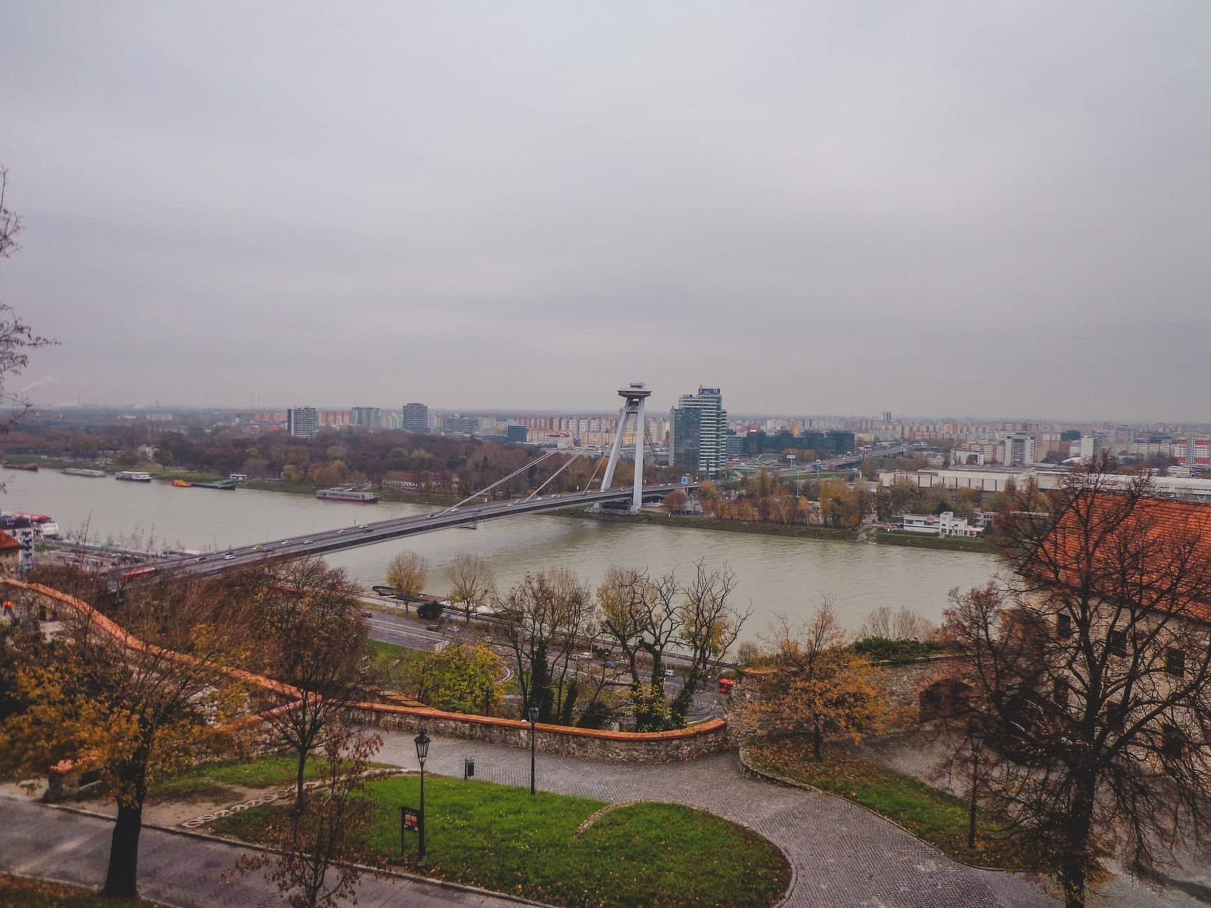 Scenic aerial view of Bratislava's modern bridge spanning across the river with city skyline.