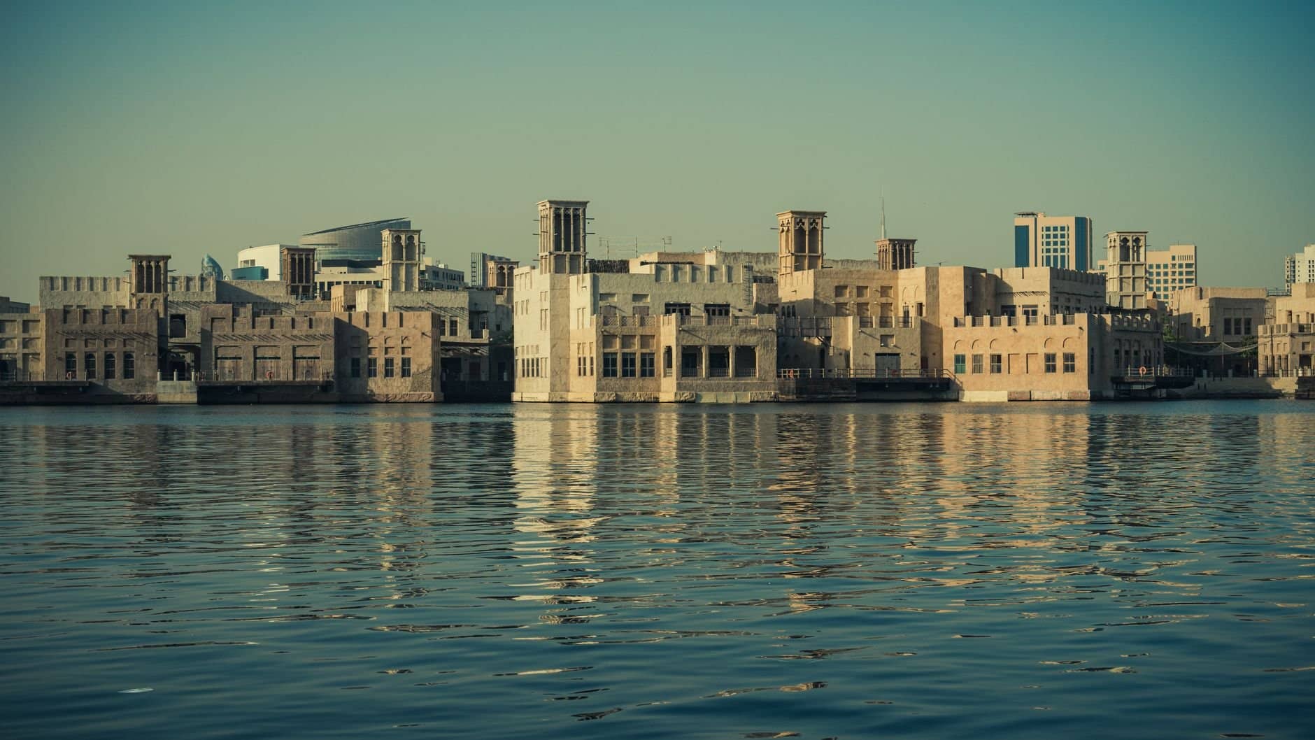 Scenic view of modern architecture reflecting on the Dubai Creek waters, showcasing Dubai's waterfront skyline.