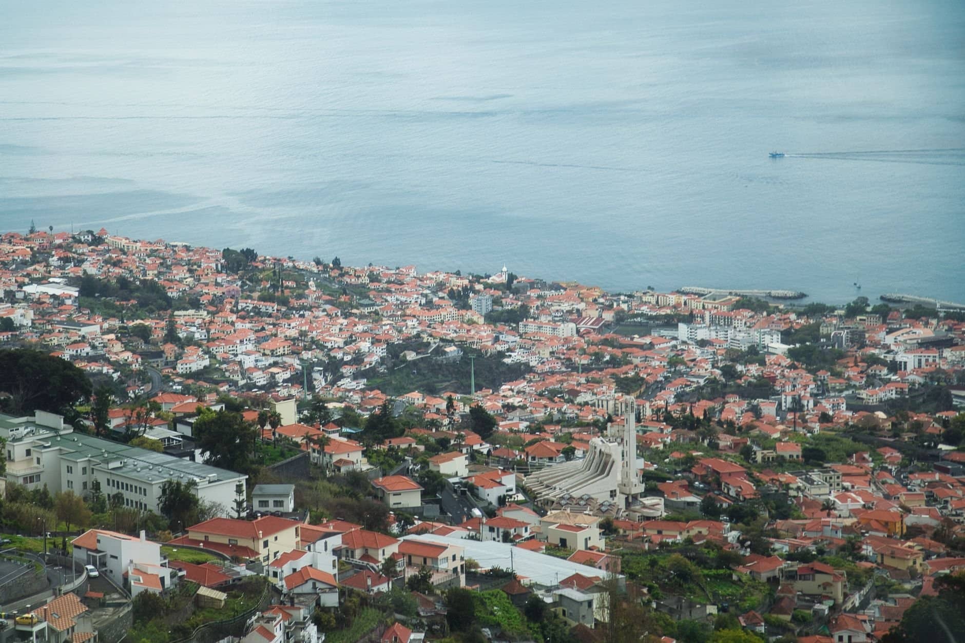 Stunning aerial view of Funchal, Madeira Island showcasing red rooftops by the sea.
