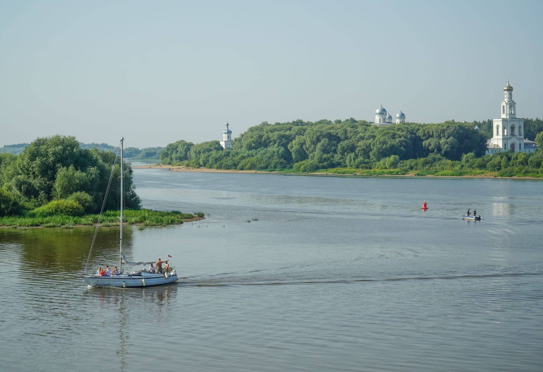 Sailboat cruising along the tranquil Volkhov River in Veliky Novgorod, Russia.