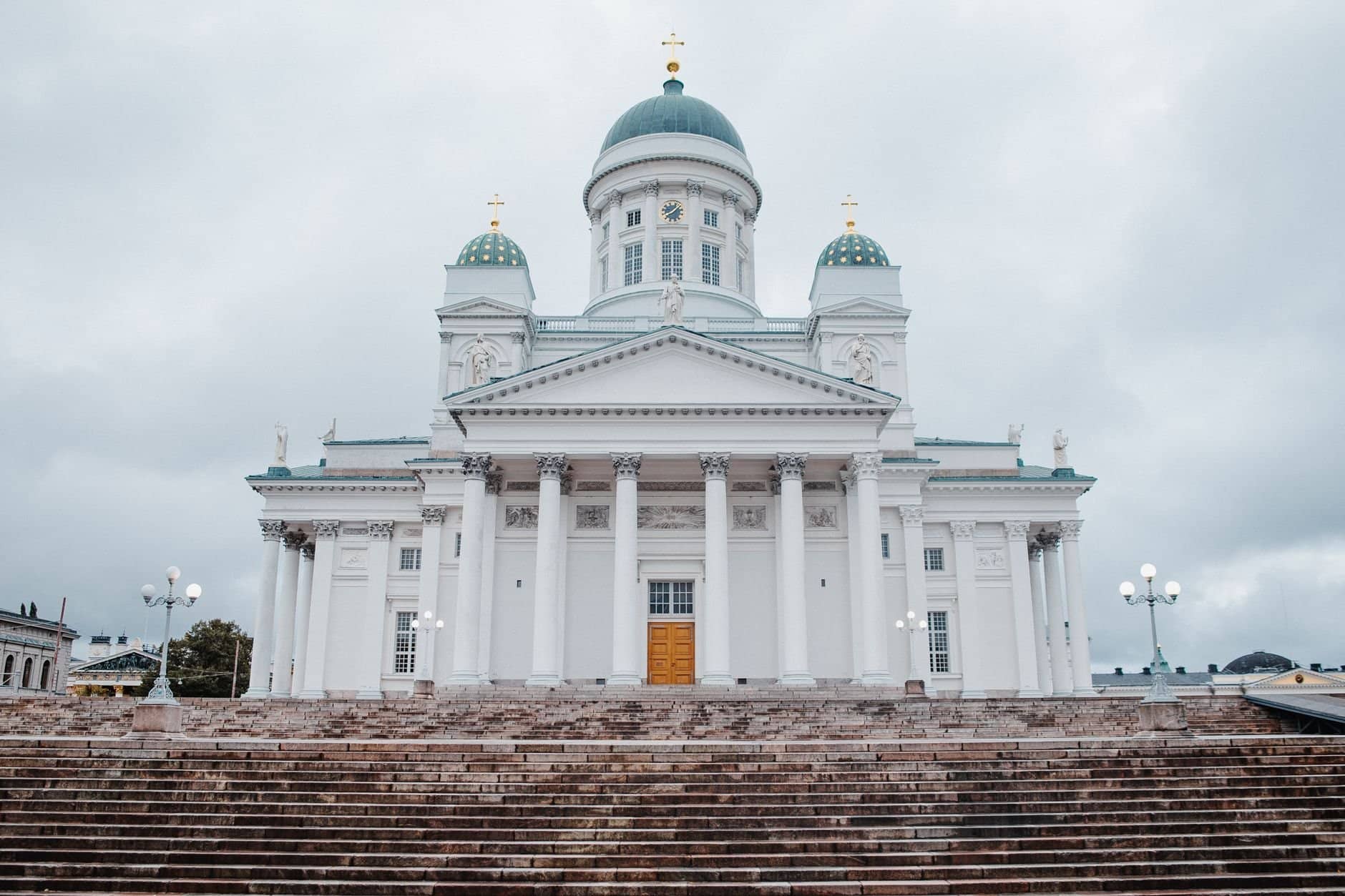 A frontal view of the iconic Helsinki Cathedral featuring neoclassical architecture under a cloudy sky.