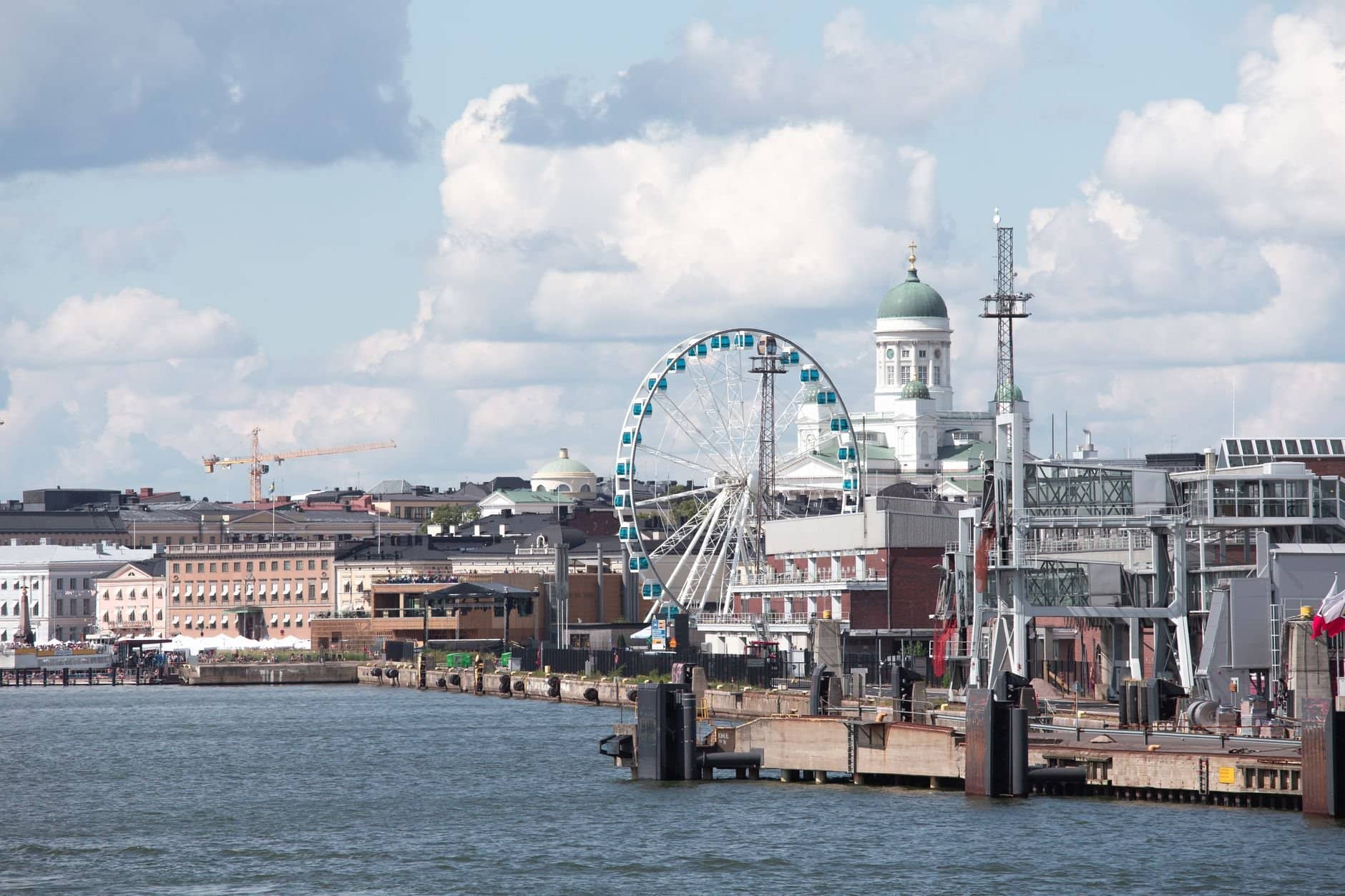Scenic Helsinki waterfront featuring the Sky Wheel and iconic Helsinki Cathedral.