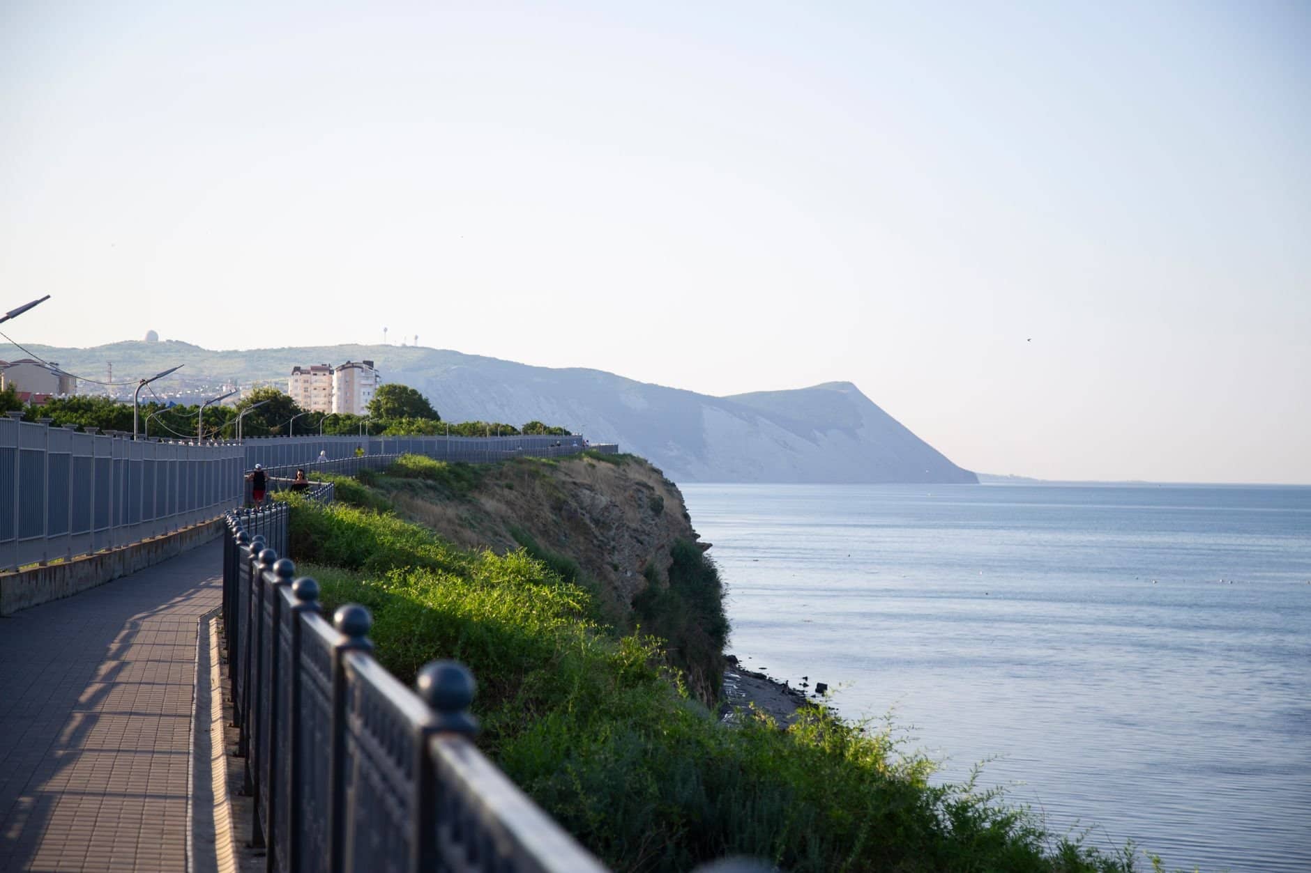 Beautiful seaside promenade with railing in Anapa, offering stunning views of the Black Sea and surrounding cliffs.