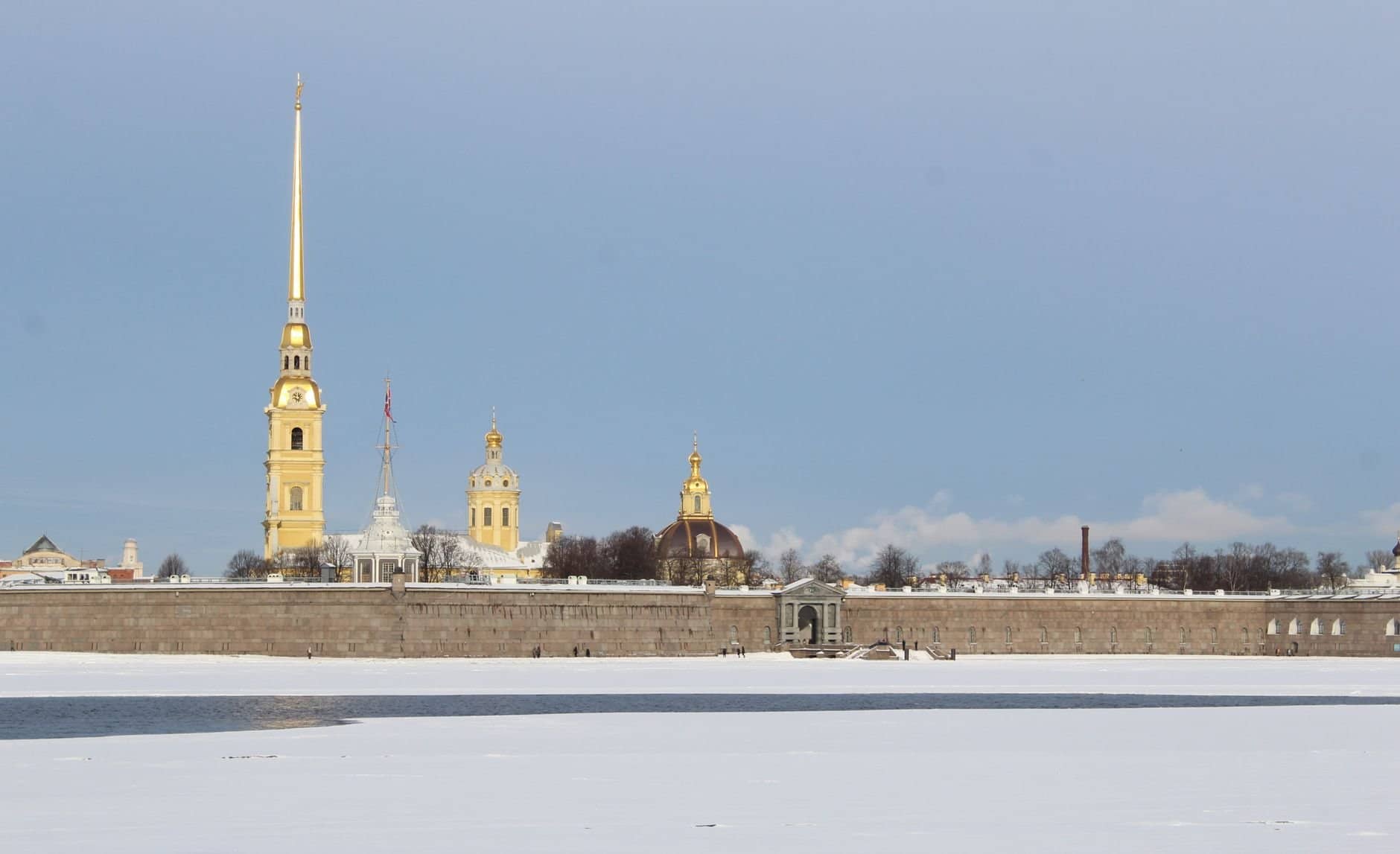 A scenic winter view of Peter and Paul Cathedral in Saint Petersburg with snow-covered landscape.