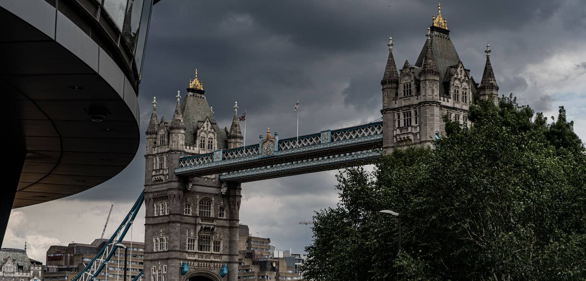 Scenic view of Tower Bridge in London, showcasing its majestic architecture under a dramatic sky.