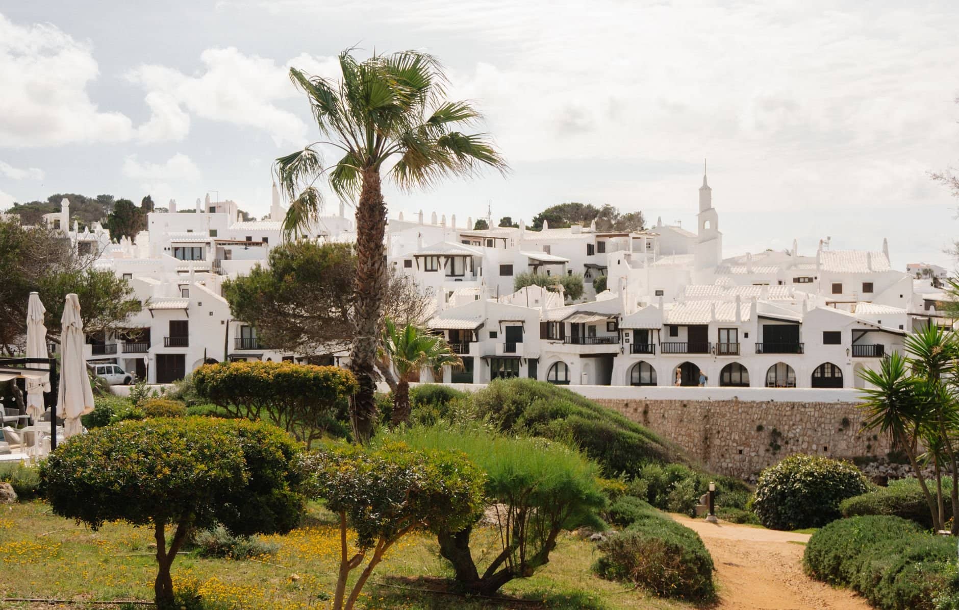 Captivating view of a whitewashed village with lush greenery in Ciutadella de Menorca.