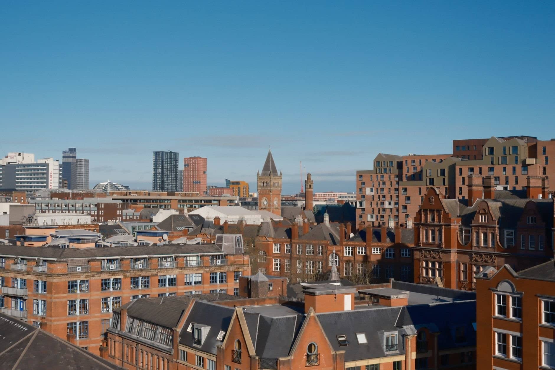 A vibrant view of Manchester showcasing modern and classic architecture under a clear sky.