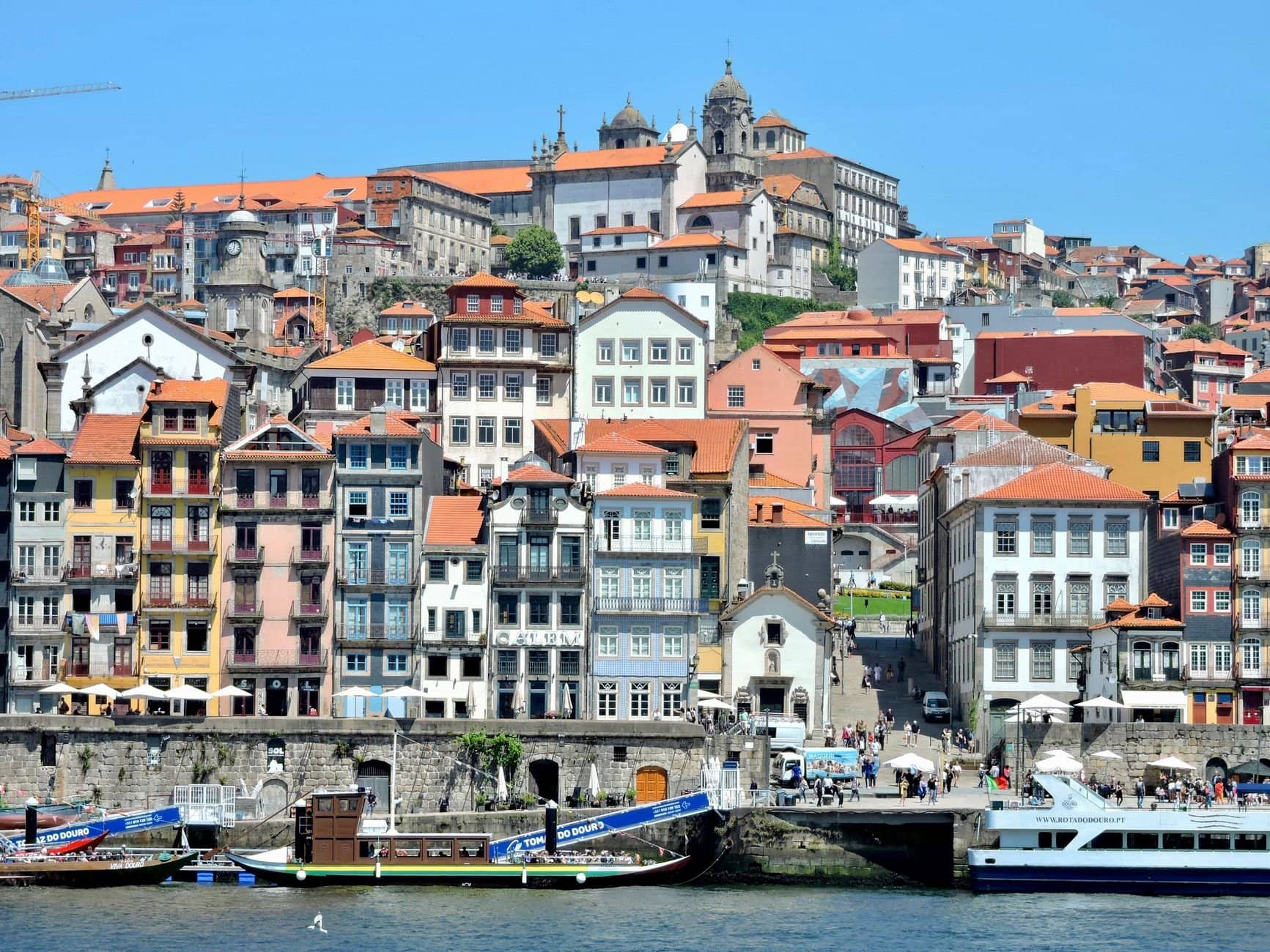 A vibrant view of the historic Ribeira District along the Douro River in Porto, Portugal.