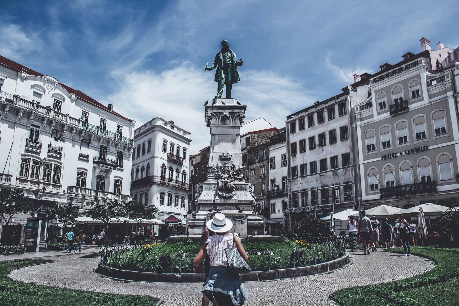 Monumental statue in a bustling Porto square, capturing local life and architecture.