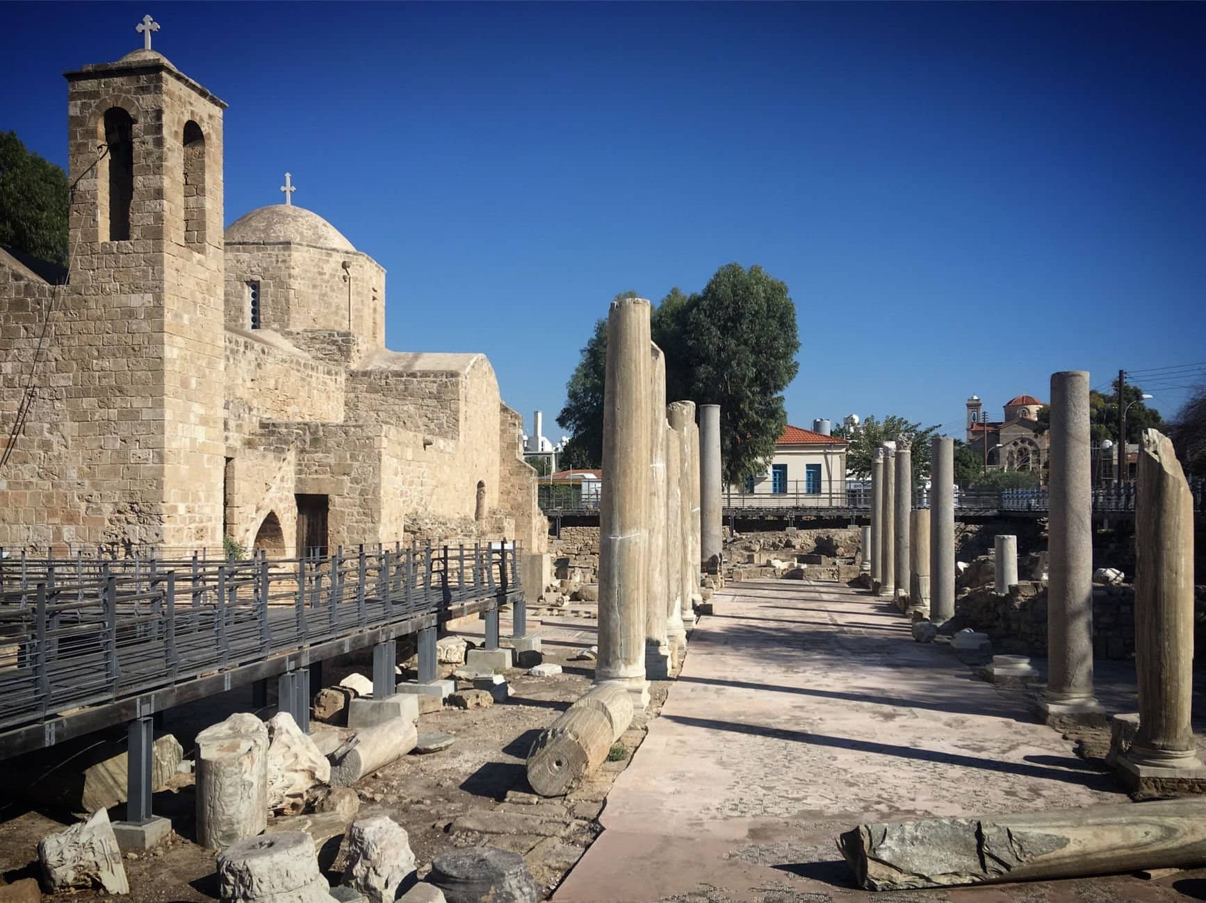 Explore the historic stone architecture and ancient ruins in Paphos, Cyprus, under clear blue skies.