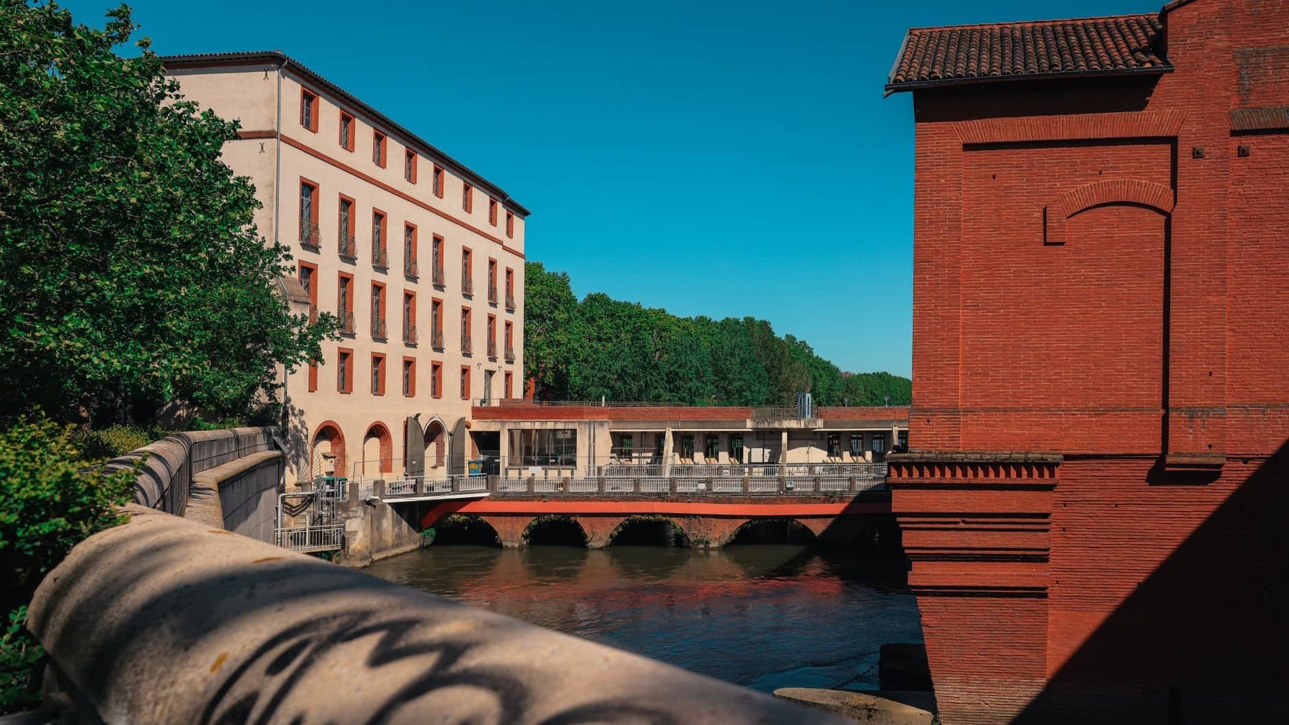 Charming view of historic buildings and a river in Toulouse, France.