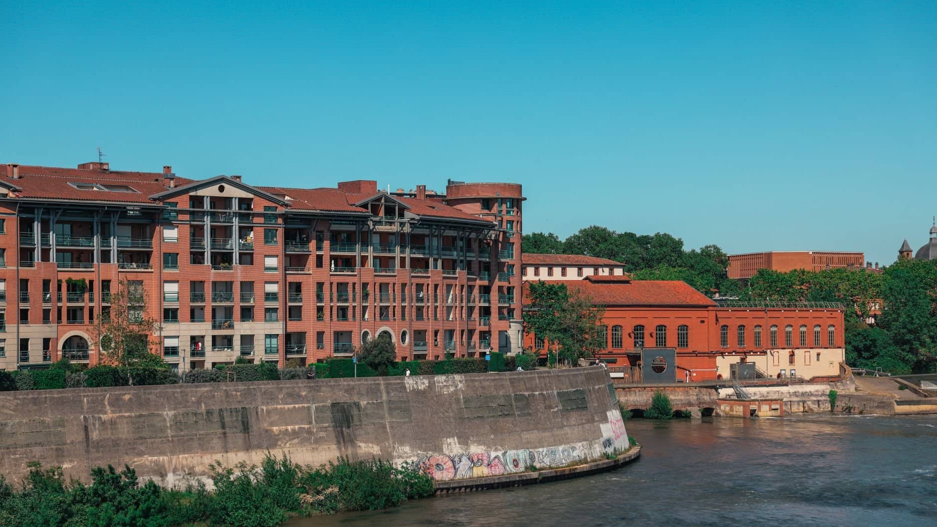 A picturesque view of brick buildings along the river in Toulouse, Occitanie, France.