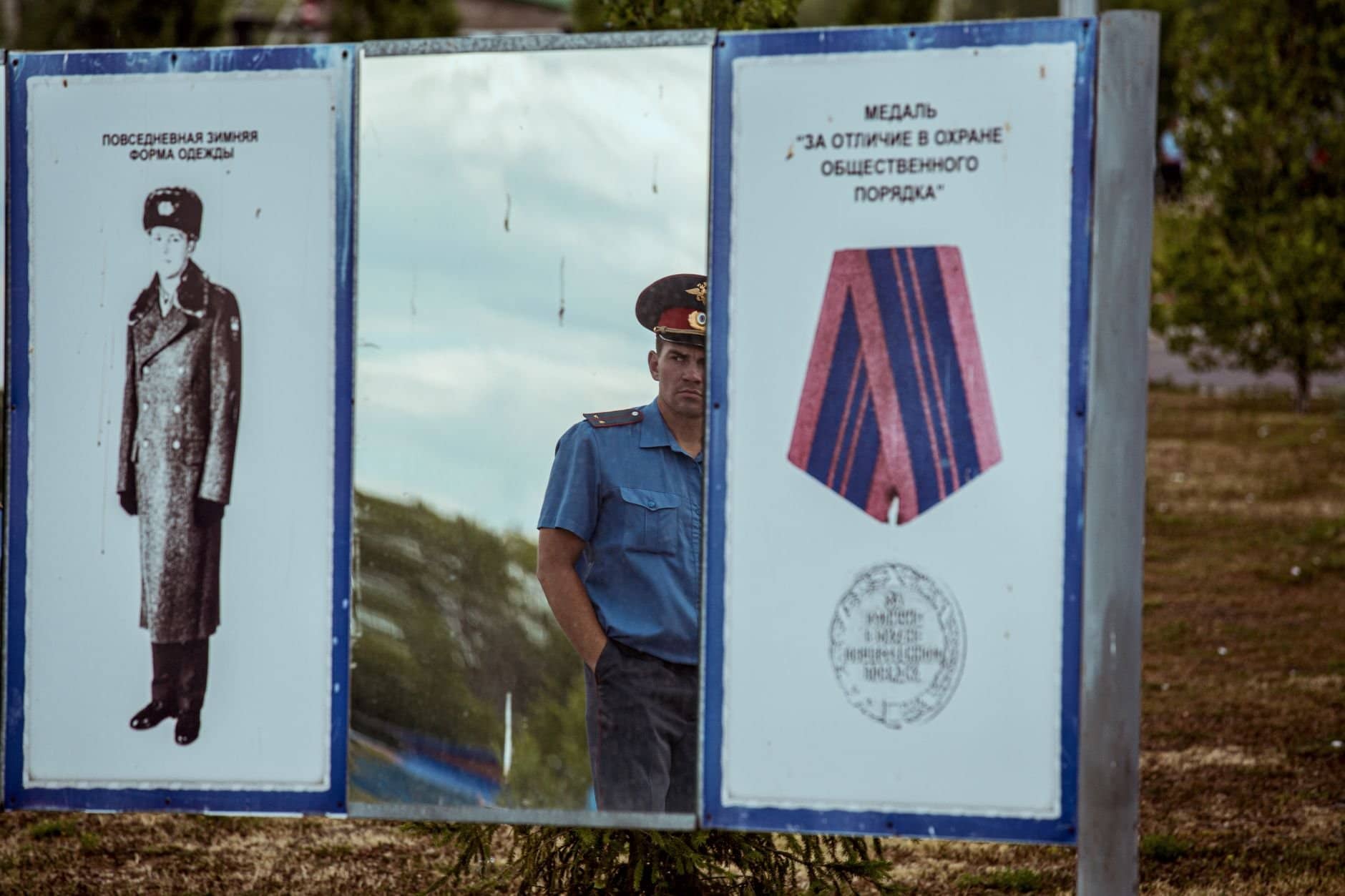 A policeman reflects in a mirror displaying Soviet military designs and medals in Ufa, Russia.