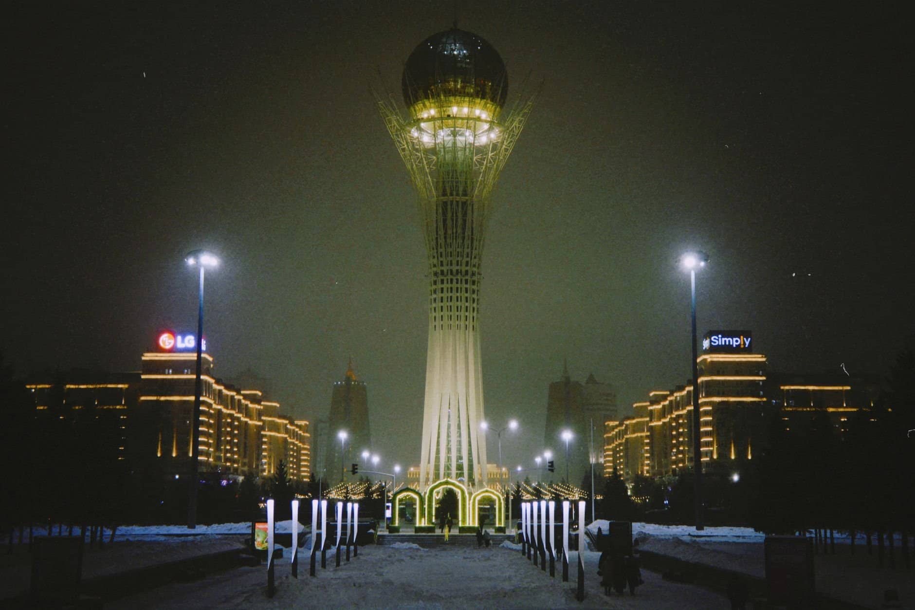 Night view of the Baiterek Tower in Astana, Kazakhstan, showcasing its illuminated skyline and architectural design.