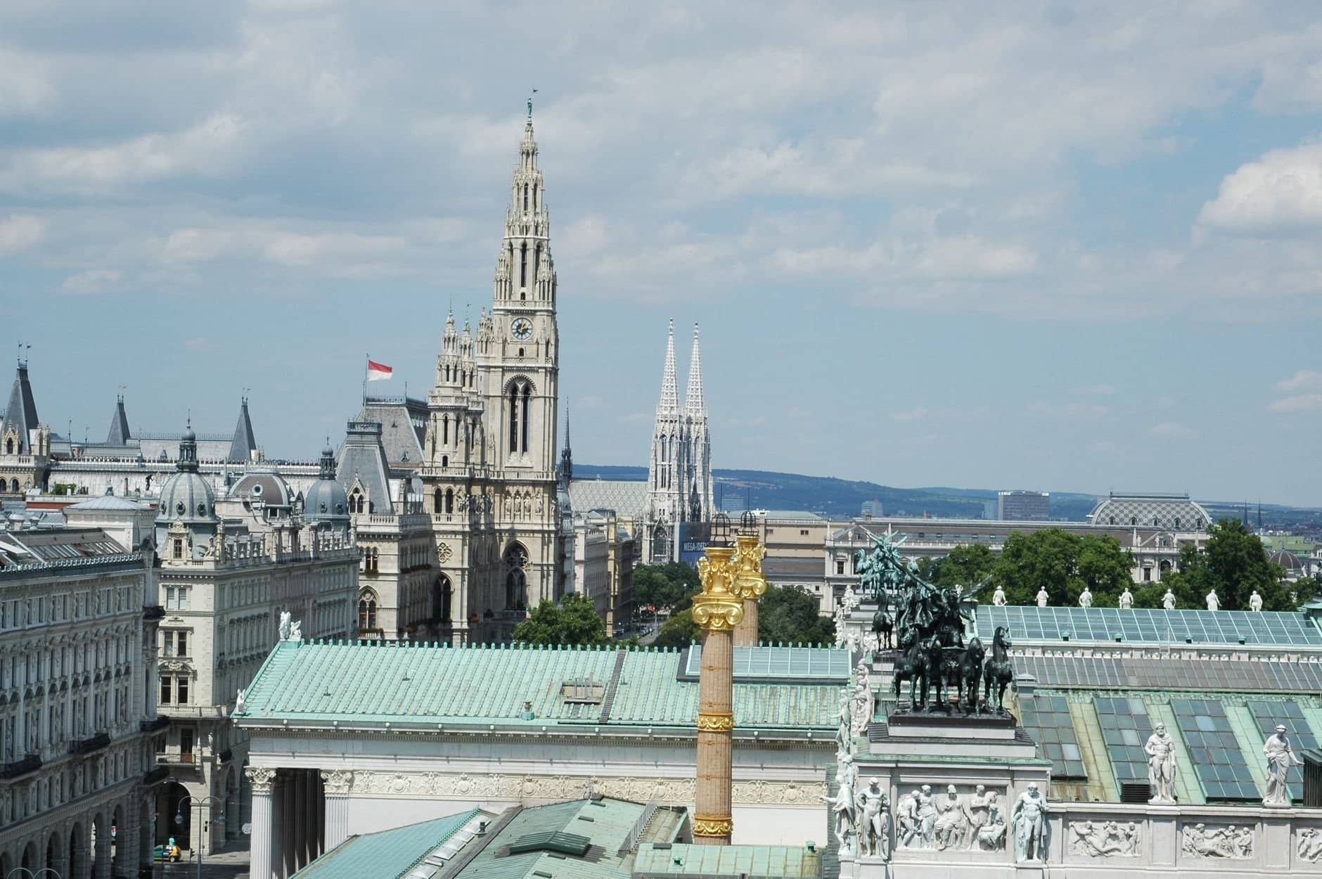 Aerial view of Vienna showcasing the town hall, Votivkirche, and architectural landmarks.