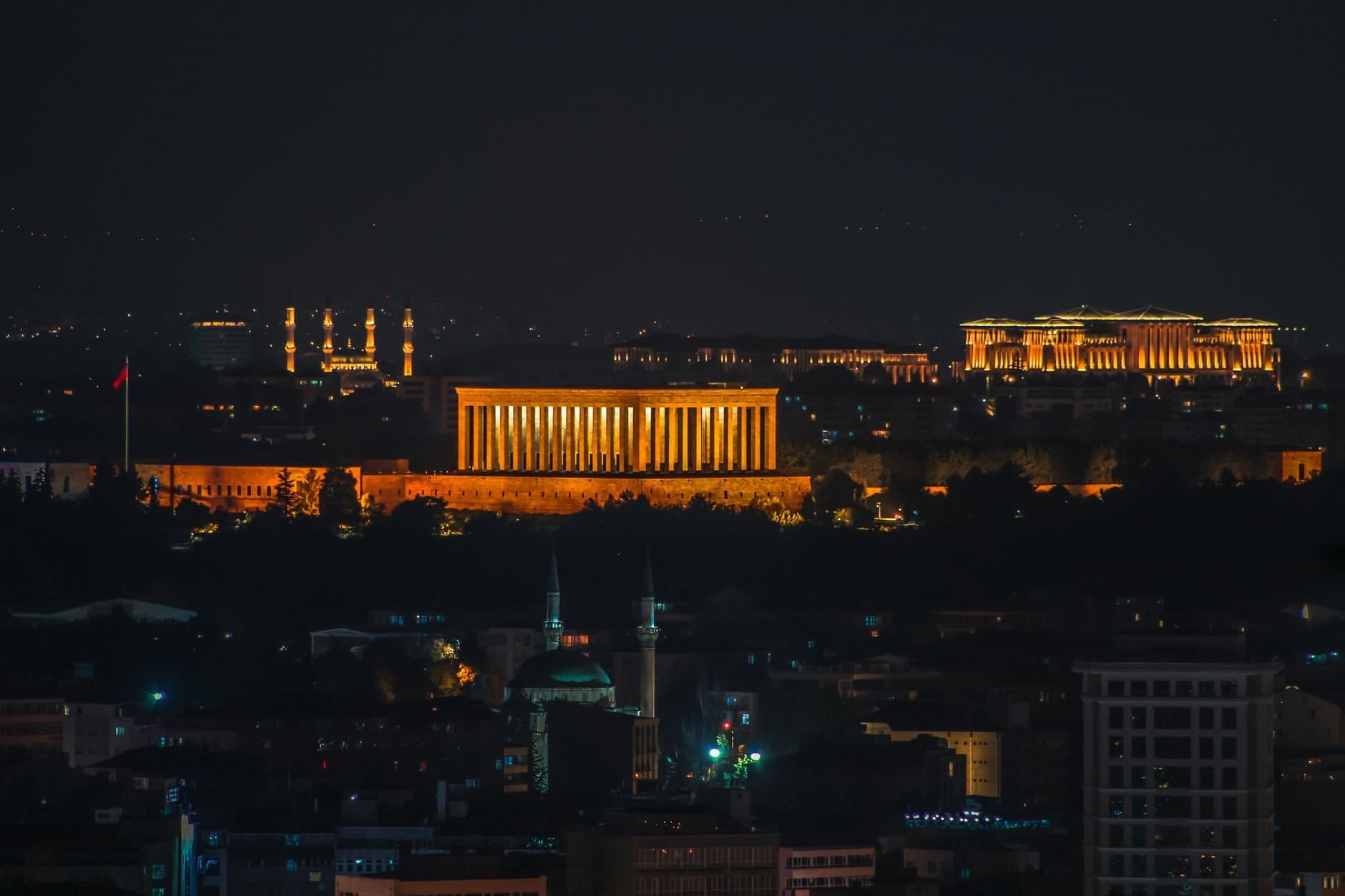 Illuminated Anıtkabir at night in Ankara cityscape, showcasing iconic architecture.