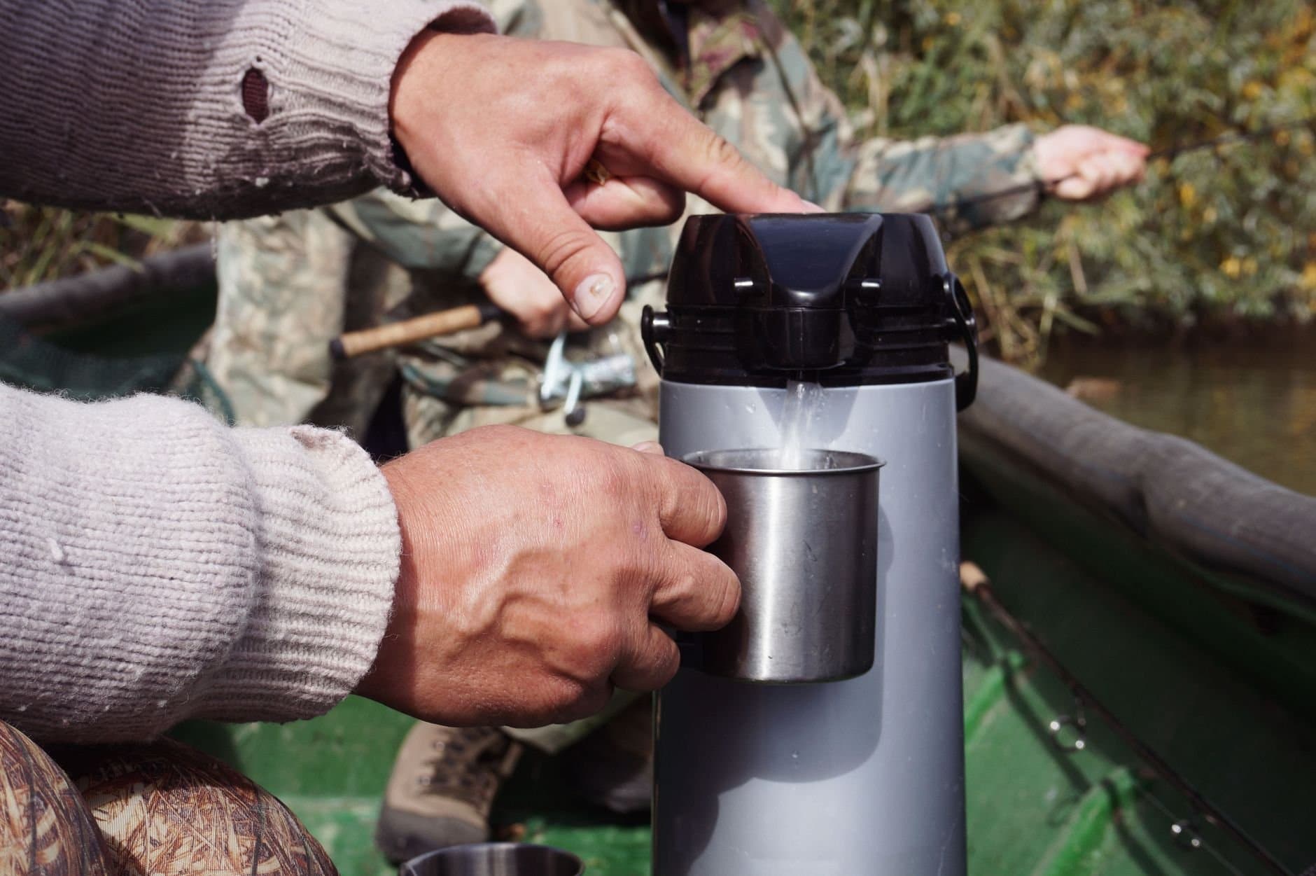 A fisherman pours a hot drink from a thermos while fishing in Astrakhan Oblast, Russia.