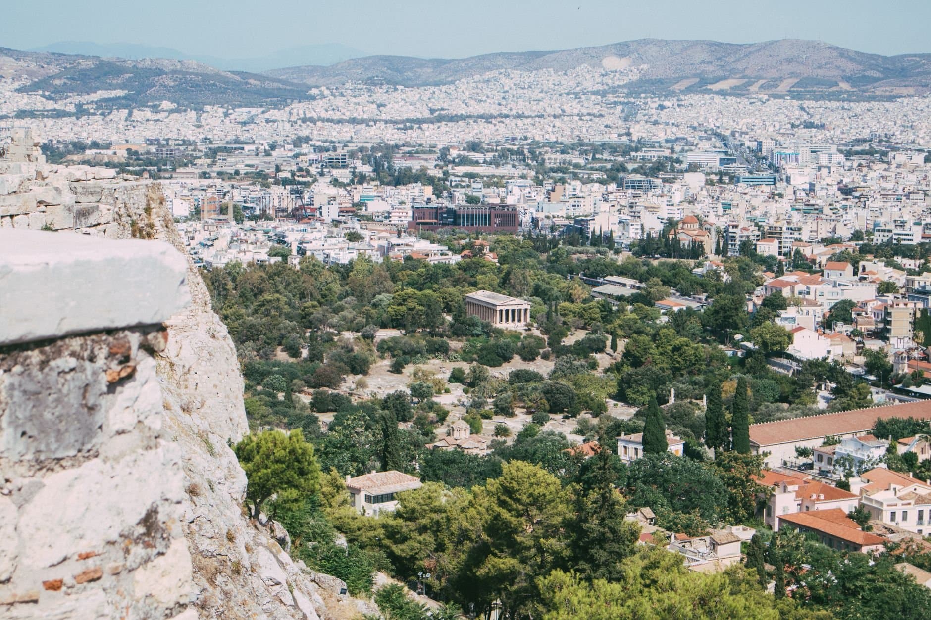 A captivating aerial view of Athens showcasing the city and ancient Agora surrounded by lush greenery.
