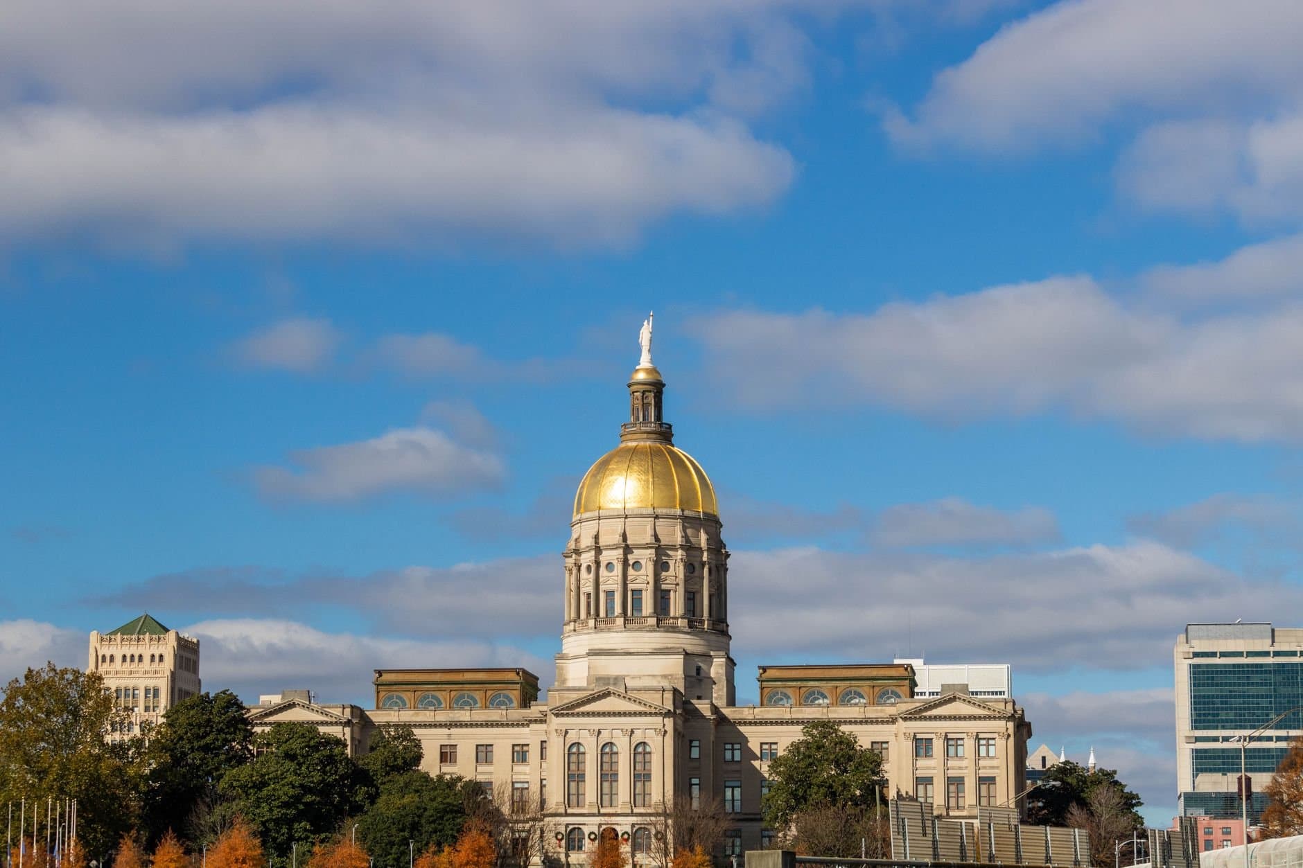 View of the Georgia State Capitol building with its iconic golden dome in Atlanta under a clear blue sky.