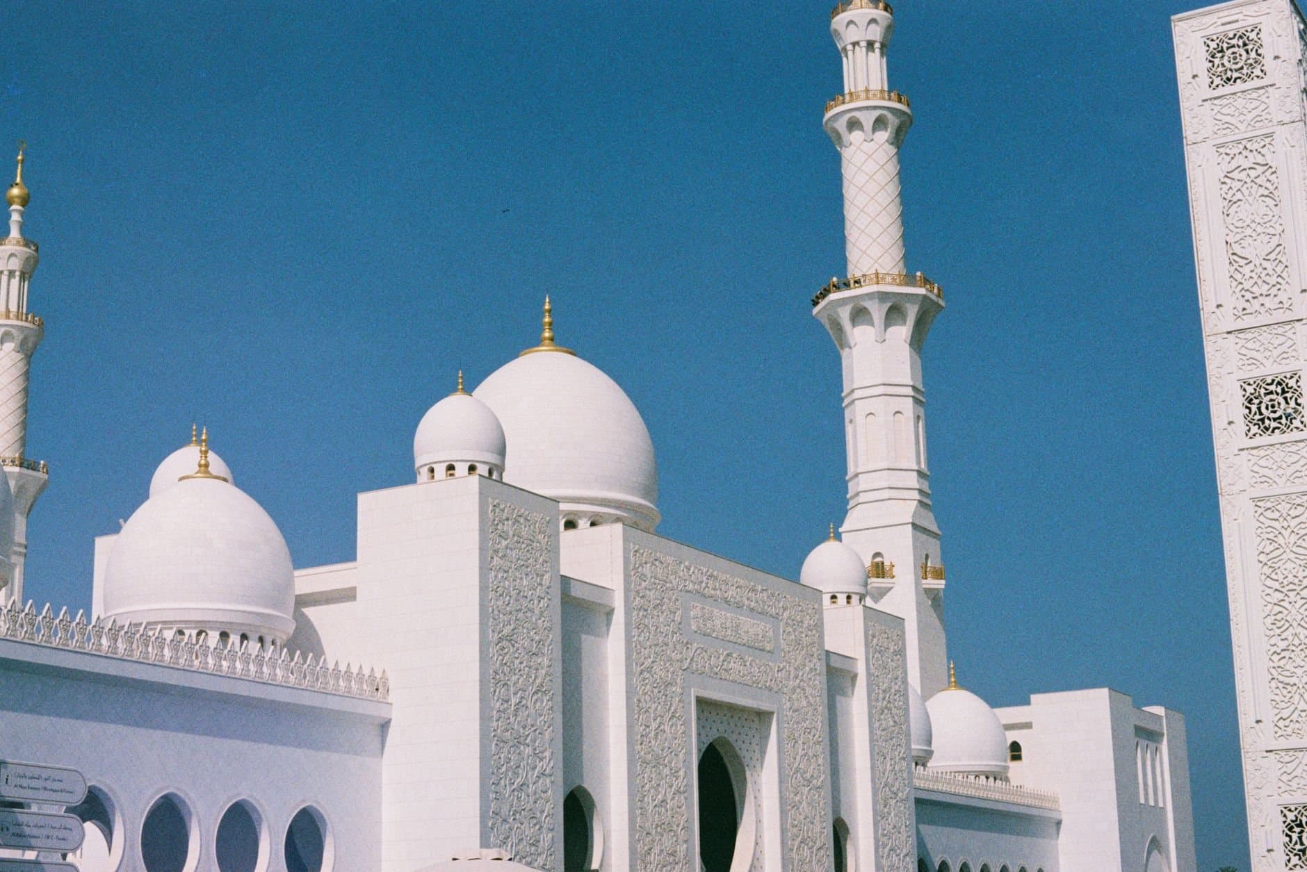 Stunning view of the Sheikh Zayed Grand Mosque in Abu Dhabi with clear blue sky.