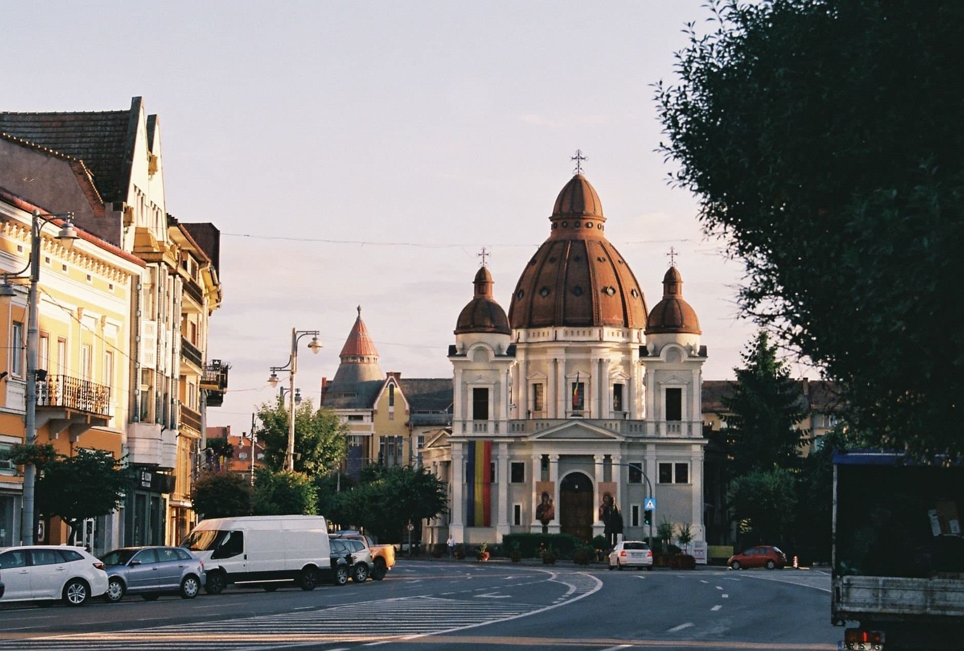 View of a historic church and surrounding architecture in a European city at sunset.