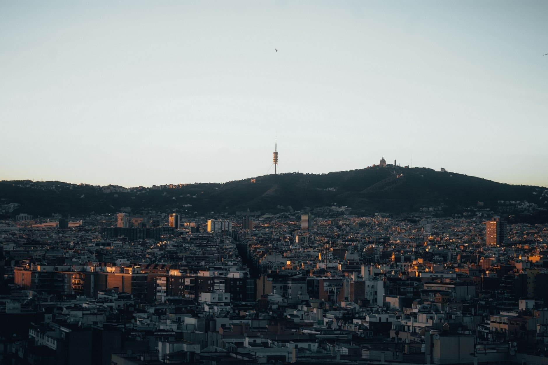 Stunning view of Barcelona with Collserola Tower silhouetted against the evening sky.