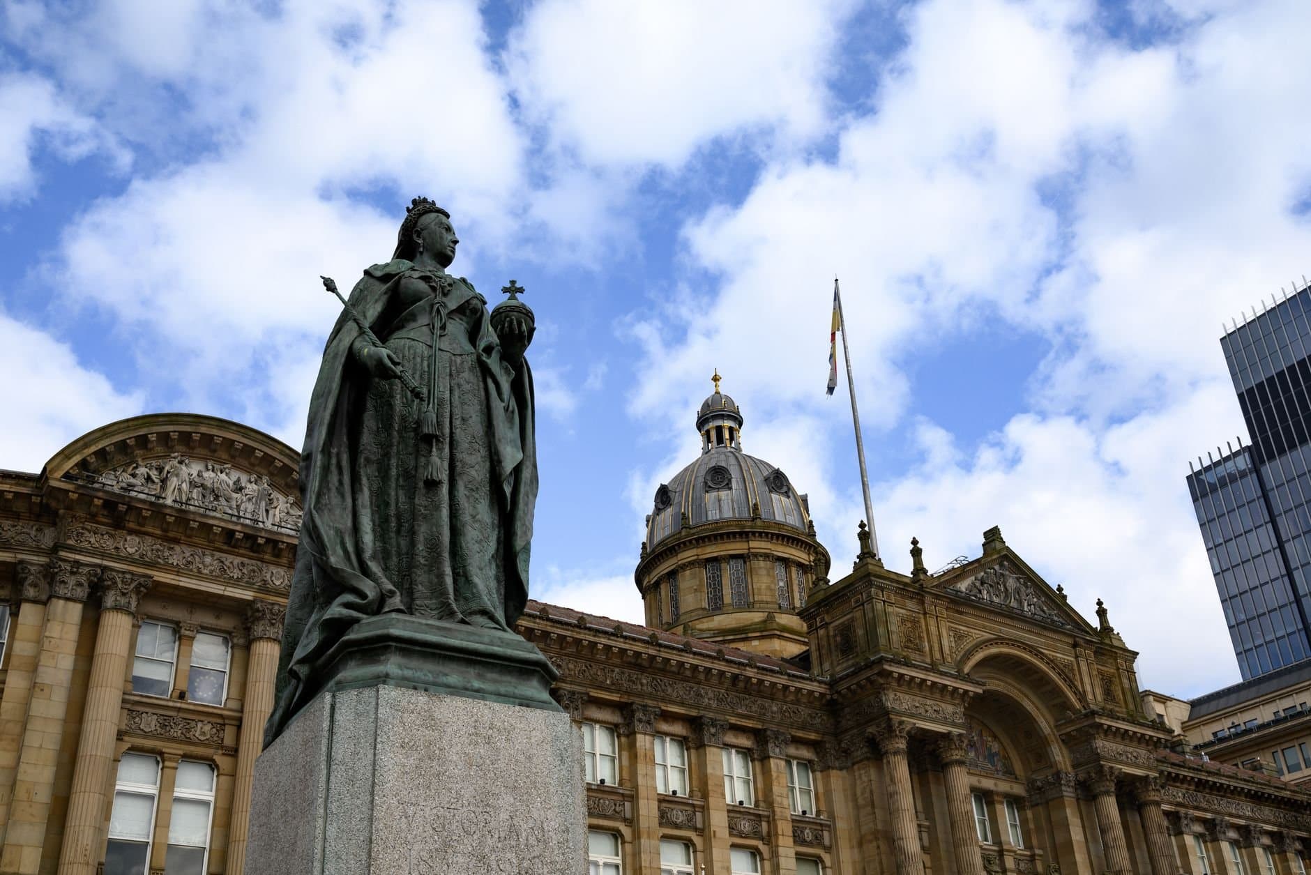 Statue of Queen Victoria outside Birmingham Council House with blue sky background.