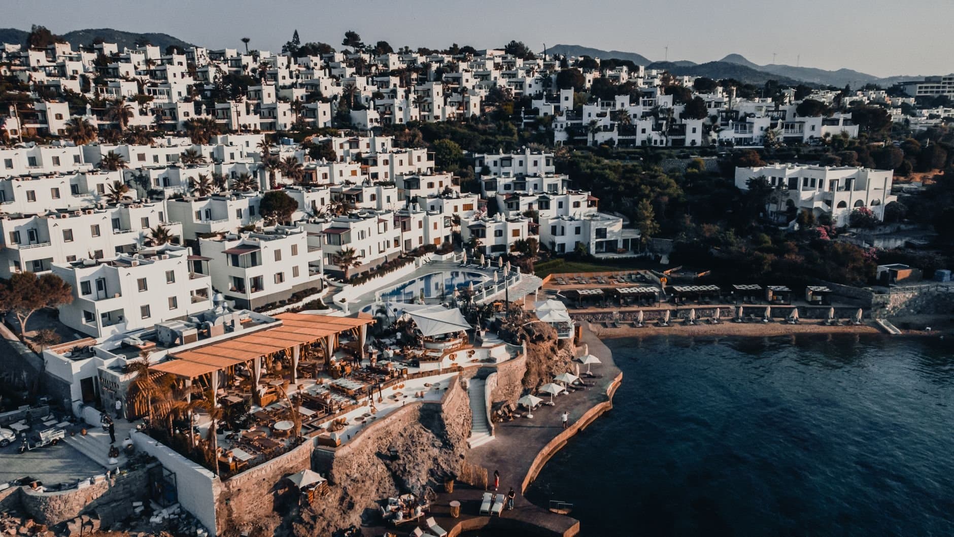 Breathtaking aerial drone shot of Bodrum's iconic whitewashed buildings along the stunning seashore.