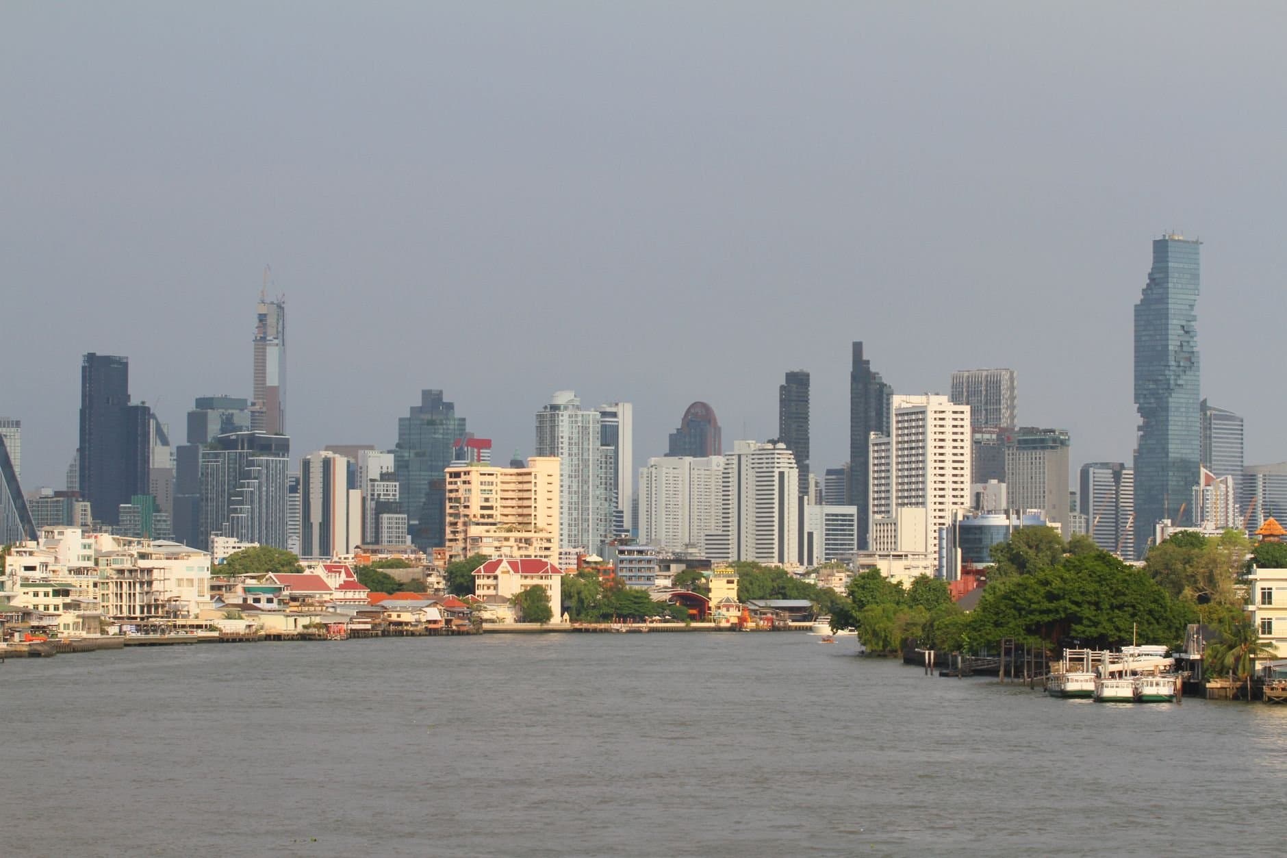 Bangkok's skyline with modern skyscrapers along the Chao Phraya River.