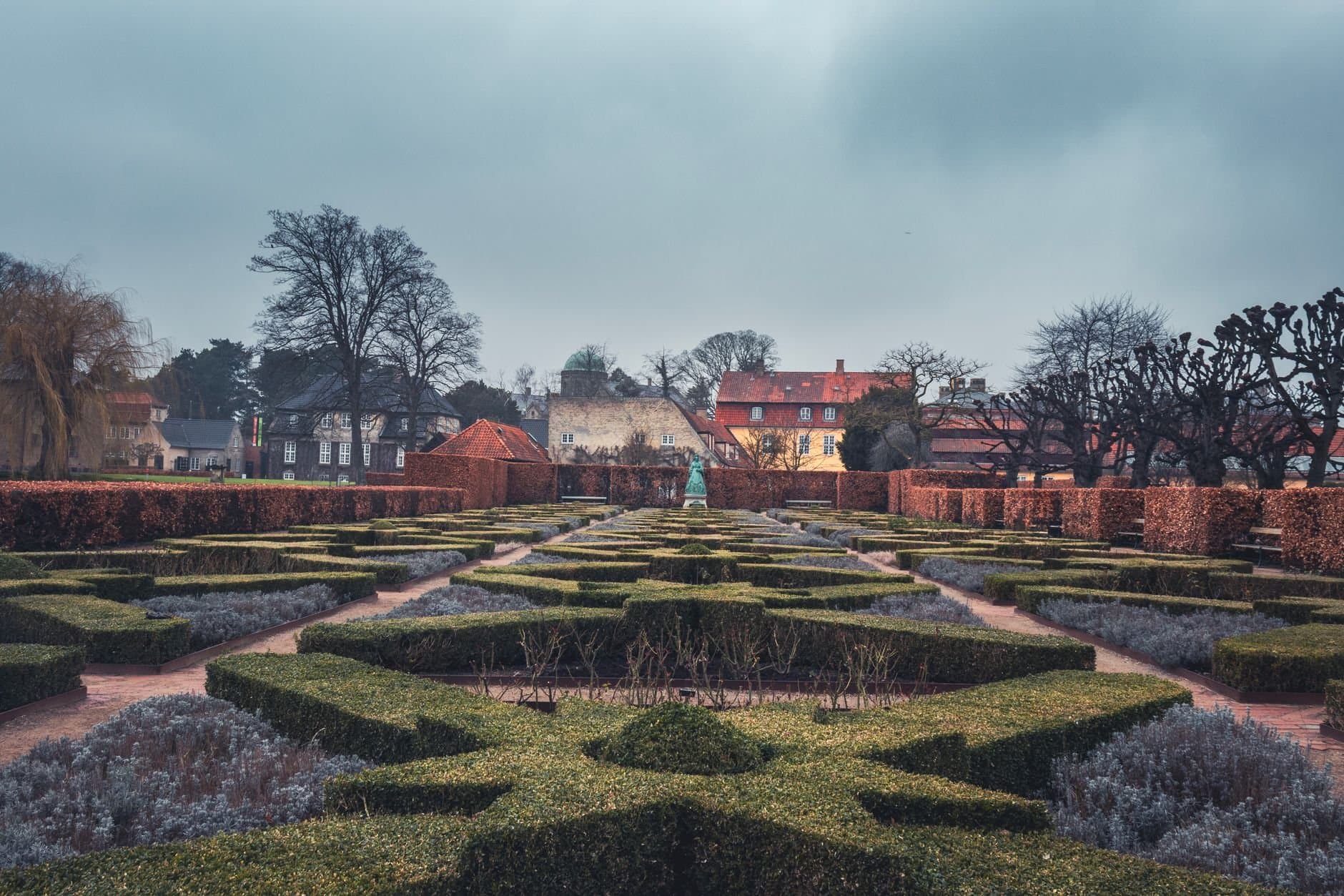 Explore the symmetrical hedges and historic architecture of a Copenhagen park.