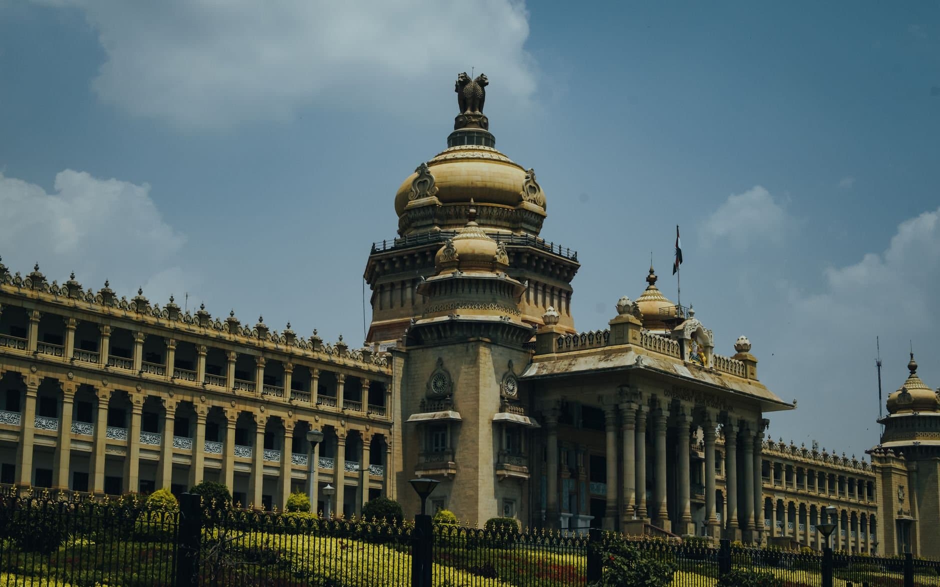 The majestic Vidhana Soudha in Bengaluru captured under a vibrant blue sky.