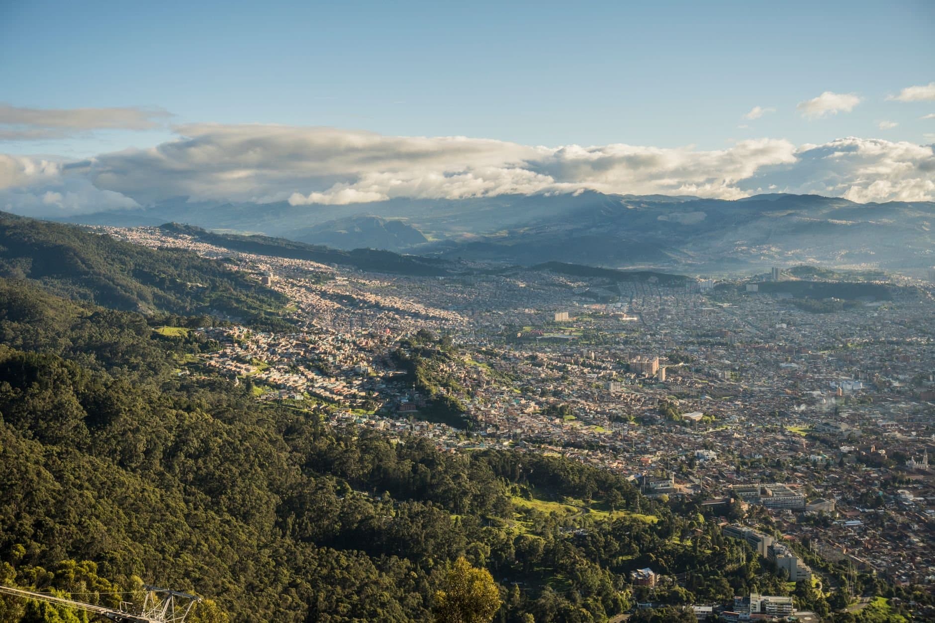 Aerial shot of Bogotá, Colombia, showcasing cityscape and surrounding lush mountains.