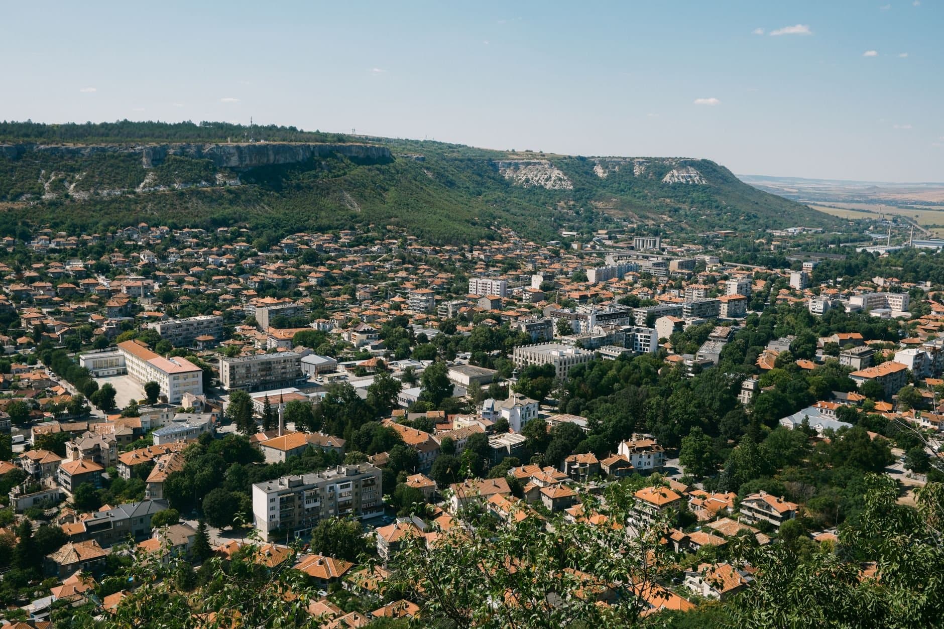 Panoramic aerial view of Varna, Bulgaria, showcasing urban architecture and surrounding greenery.