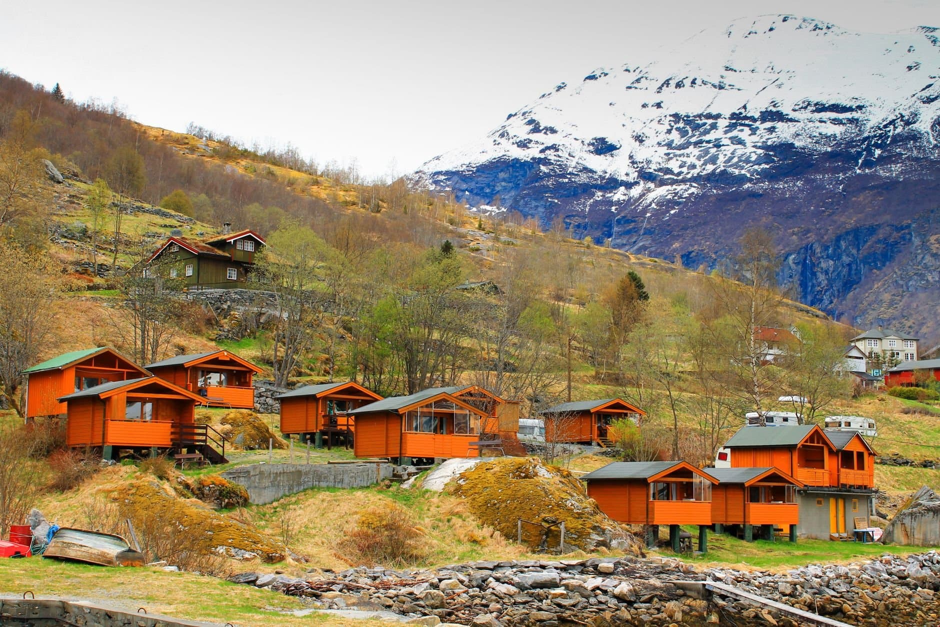 Charming Norwegian village nestled in the mountains with vibrant orange cabins.