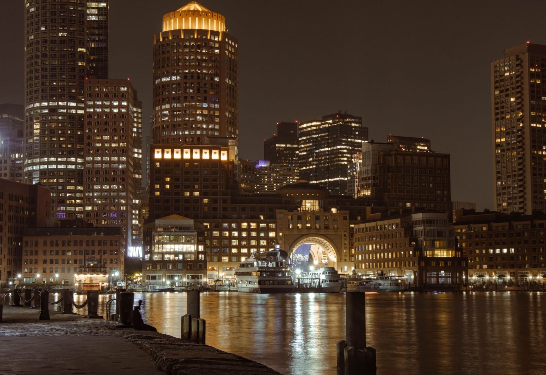 Stunning view of Boston's illuminated skyline and harbor at night showcasing iconic landmarks.