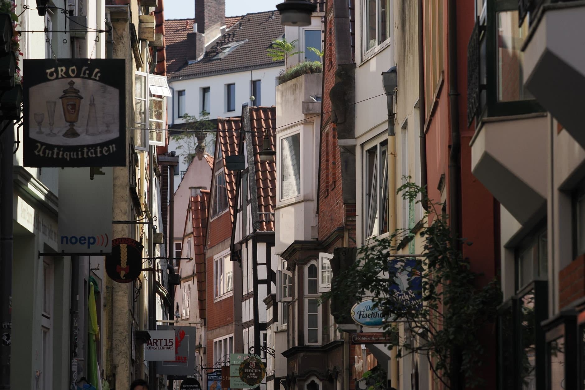 A picturesque street in Bremen showcasing historic architecture and quaint storefronts bathed in daylight.