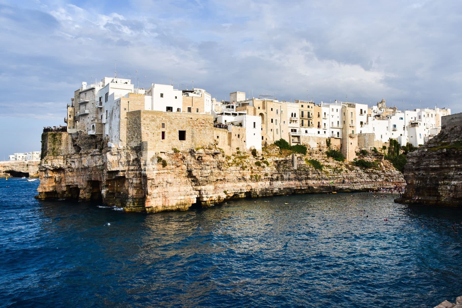 Picturesque view of Polignano a Mare with white-washed buildings perched on cliffs above the azure sea.