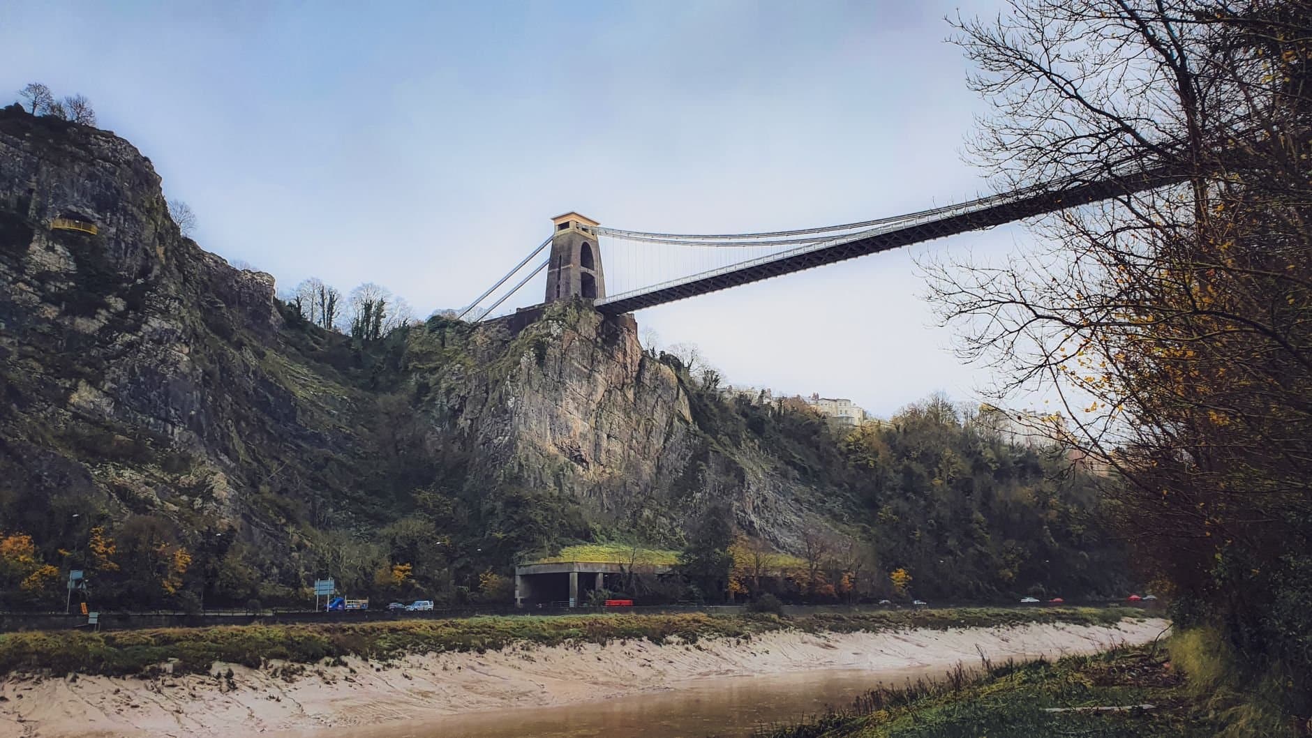 Stunning view of a suspension bridge spanning a rocky gorge with a scenic river below.