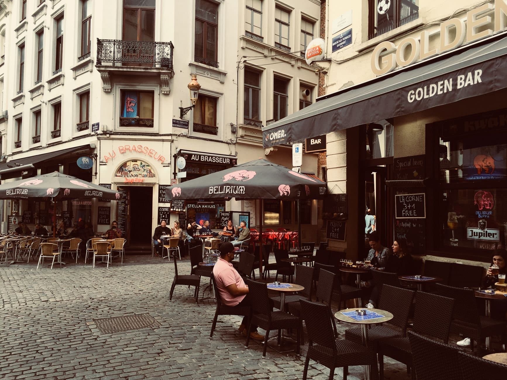 Outdoor cafes in a historic Brussels street, capturing the vibrant city life and European architecture.