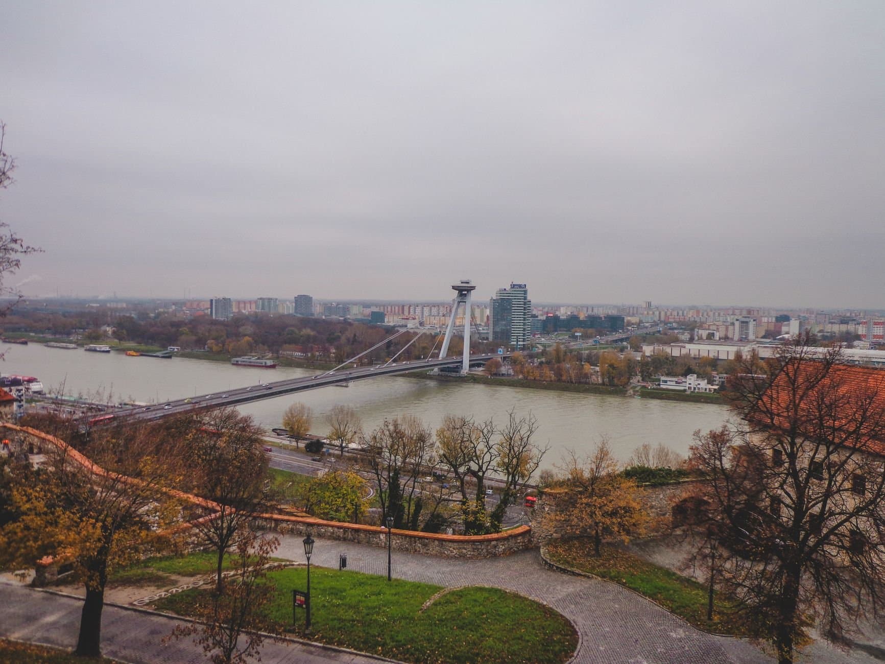 Scenic aerial view of Bratislava's modern bridge spanning across the river with city skyline.