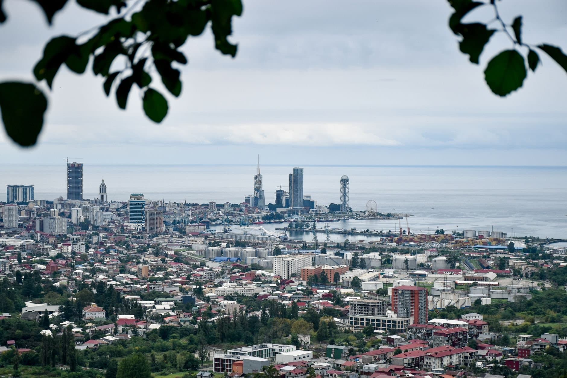 Scenic aerial view of Batumi cityscape and the Black Sea with modern architecture and lush greenery.