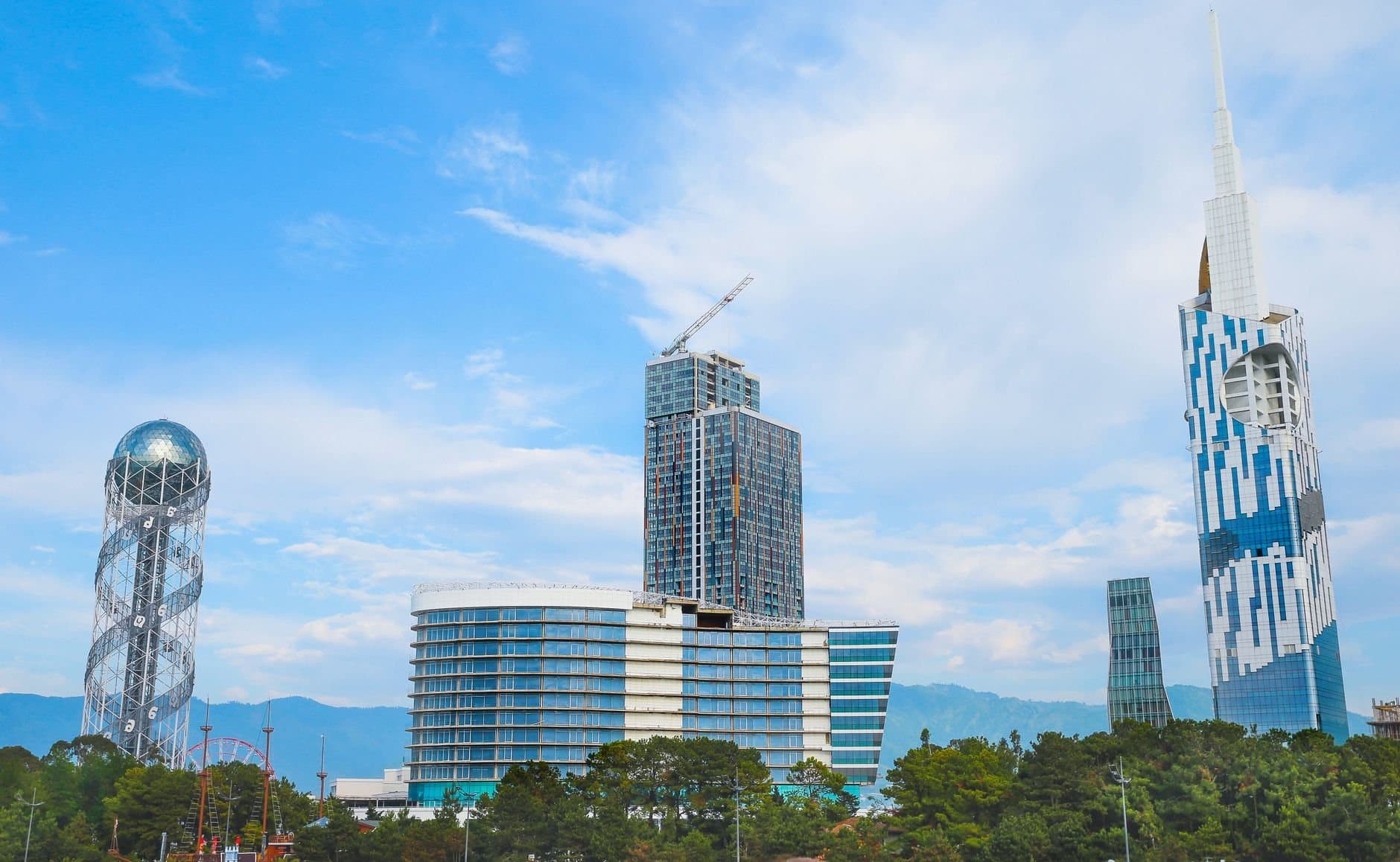 Vibrant urban skyline featuring modern skyscrapers and unique architectural towers against a blue sky.