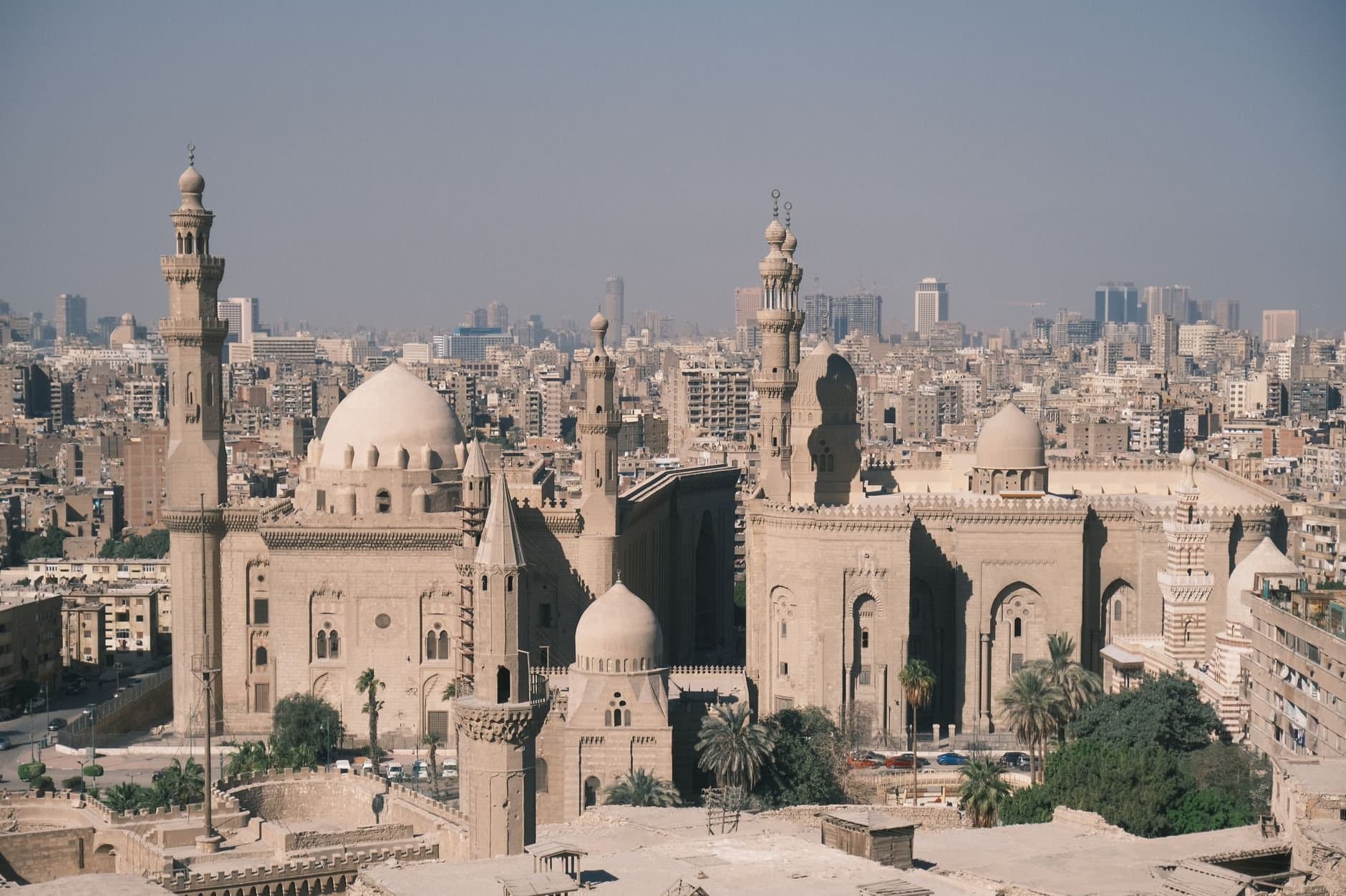 Scenic aerial view of Cairo with the iconic Mosque-Madrassa of Sultan Hassan and city skyline.
