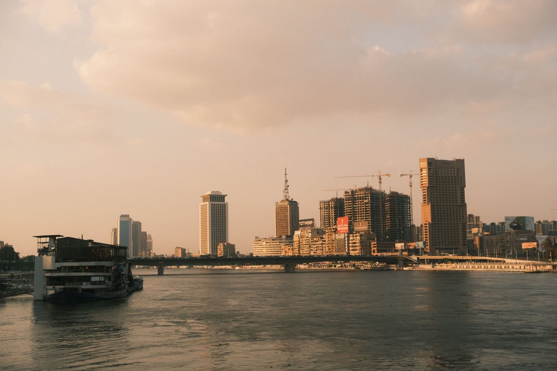A scenic view of Cairo's skyline along the Nile River at sunset, capturing the city's modern architecture.