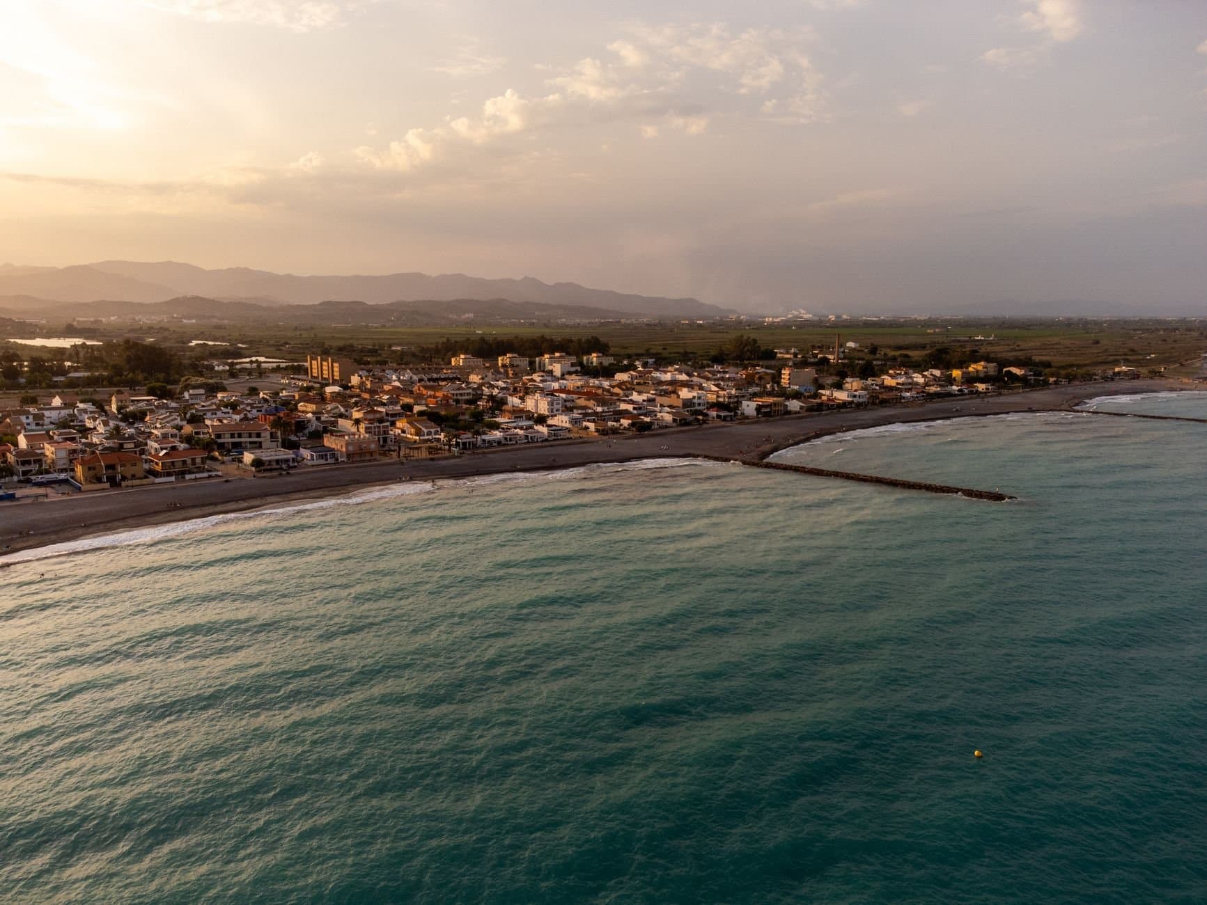 Captivating aerial view of Casablanca, Spain's coastline at sunset, showcasing tranquil waters and scenic urban landscape.