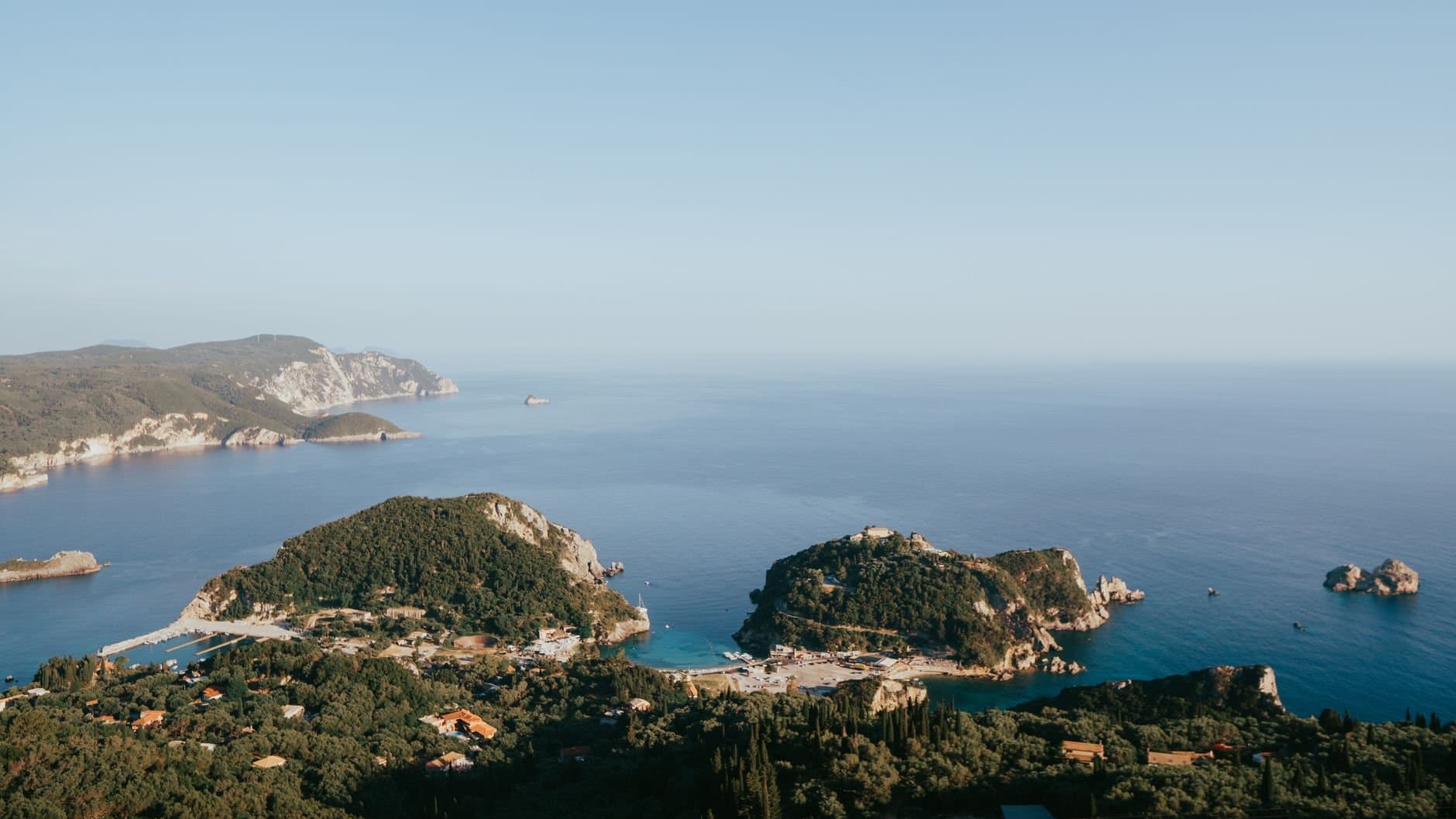 Breathtaking aerial view of Corfu coastline with lush greenery and sparkling blue sea in summer.