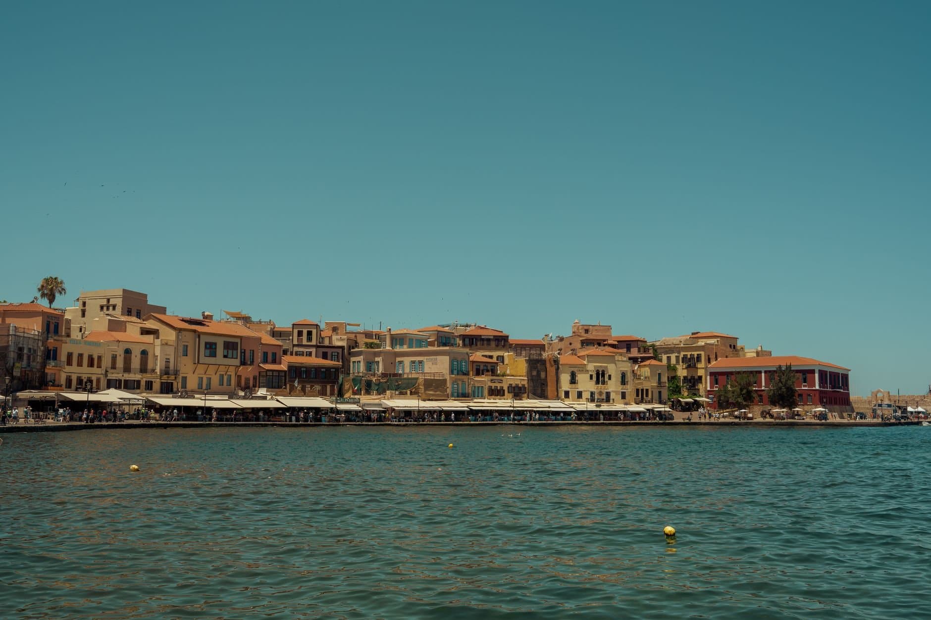 Scenic view of Chania Old Town and harbor, Crete, Greece, under clear blue sky.